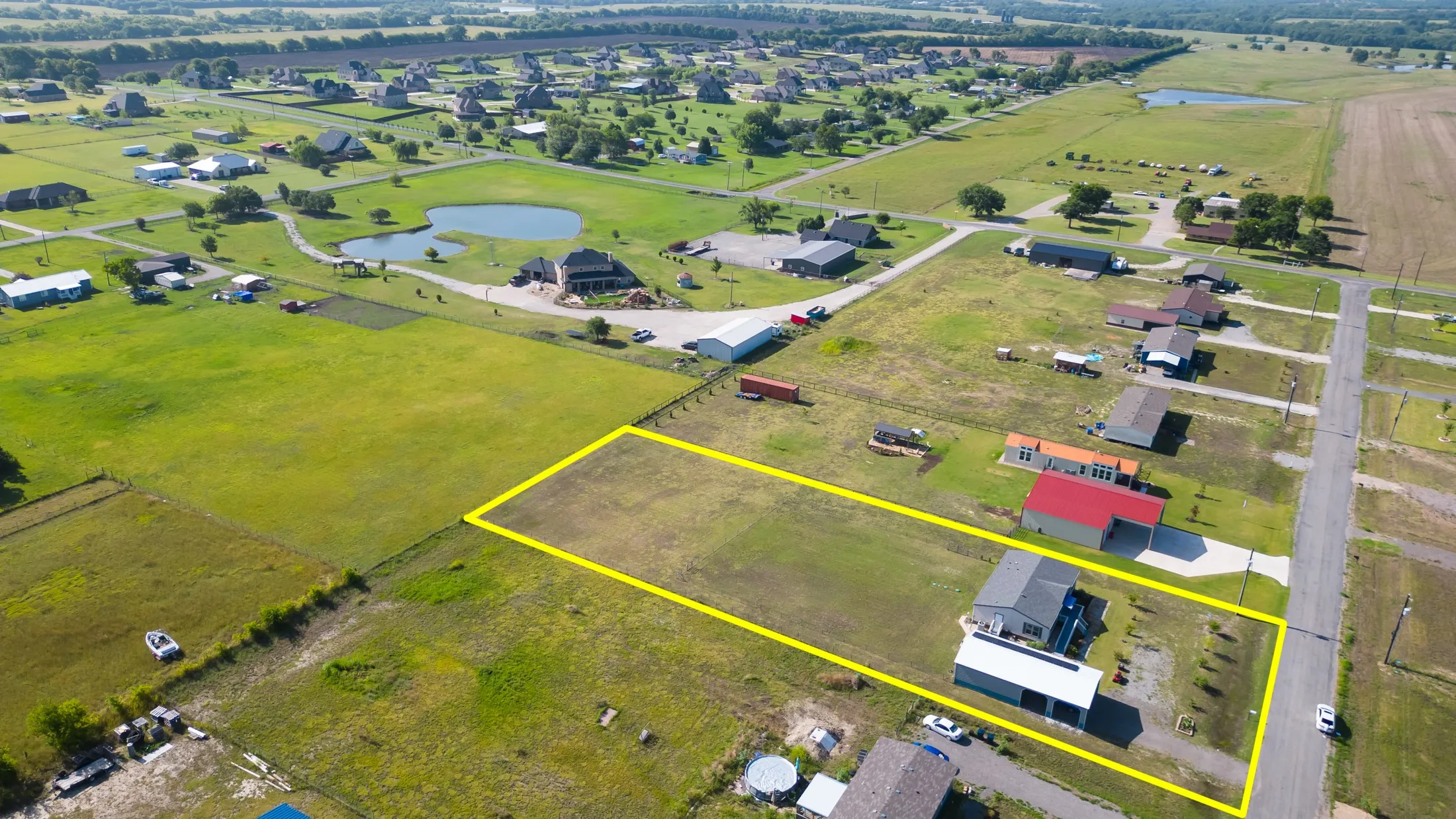 Aerial perspective showcasing a residential property with an expansive grass lot