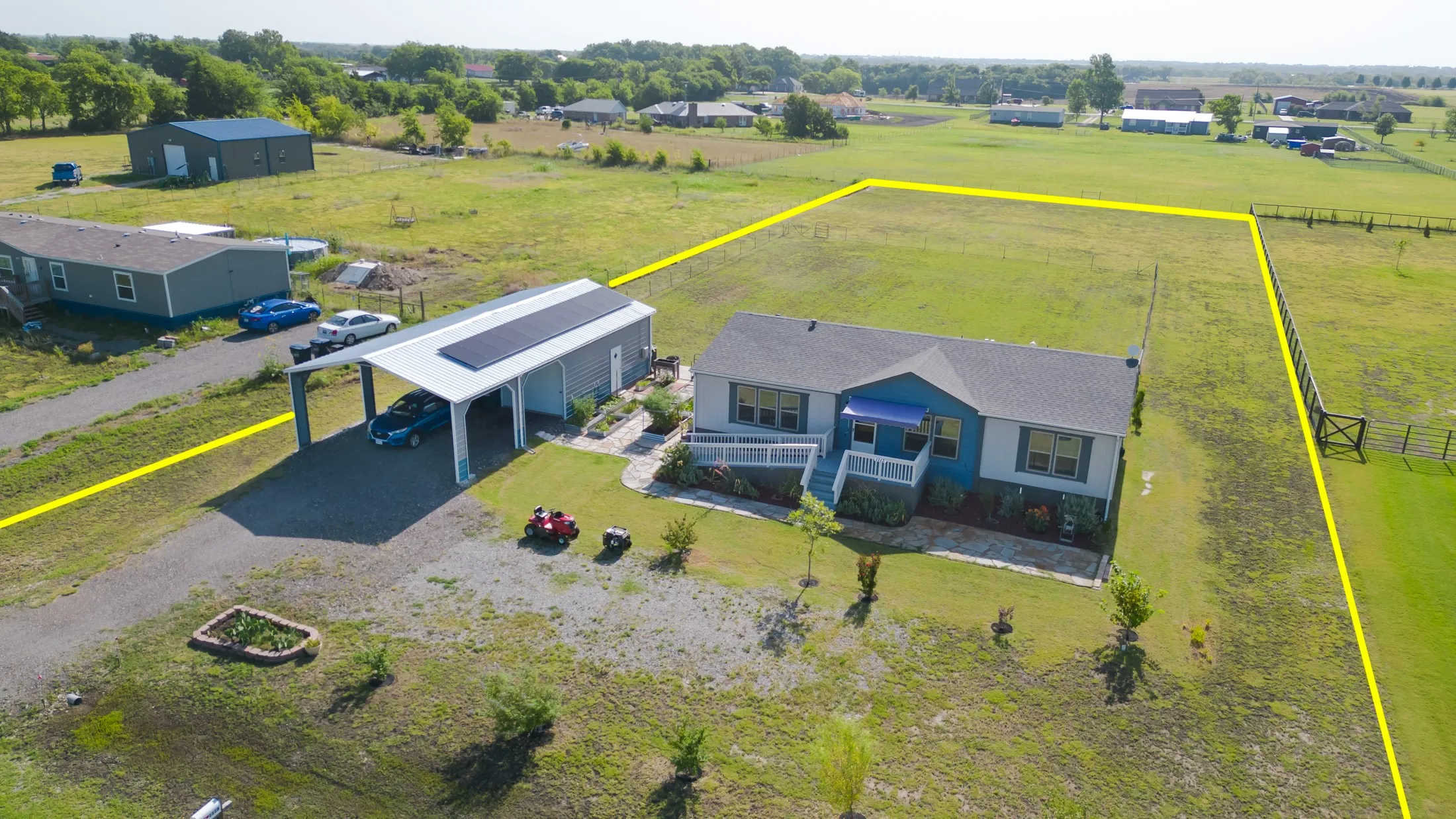 Single-story residence on a one acre lot featuring a blue and white exterior, covered front porch, and an attached carport