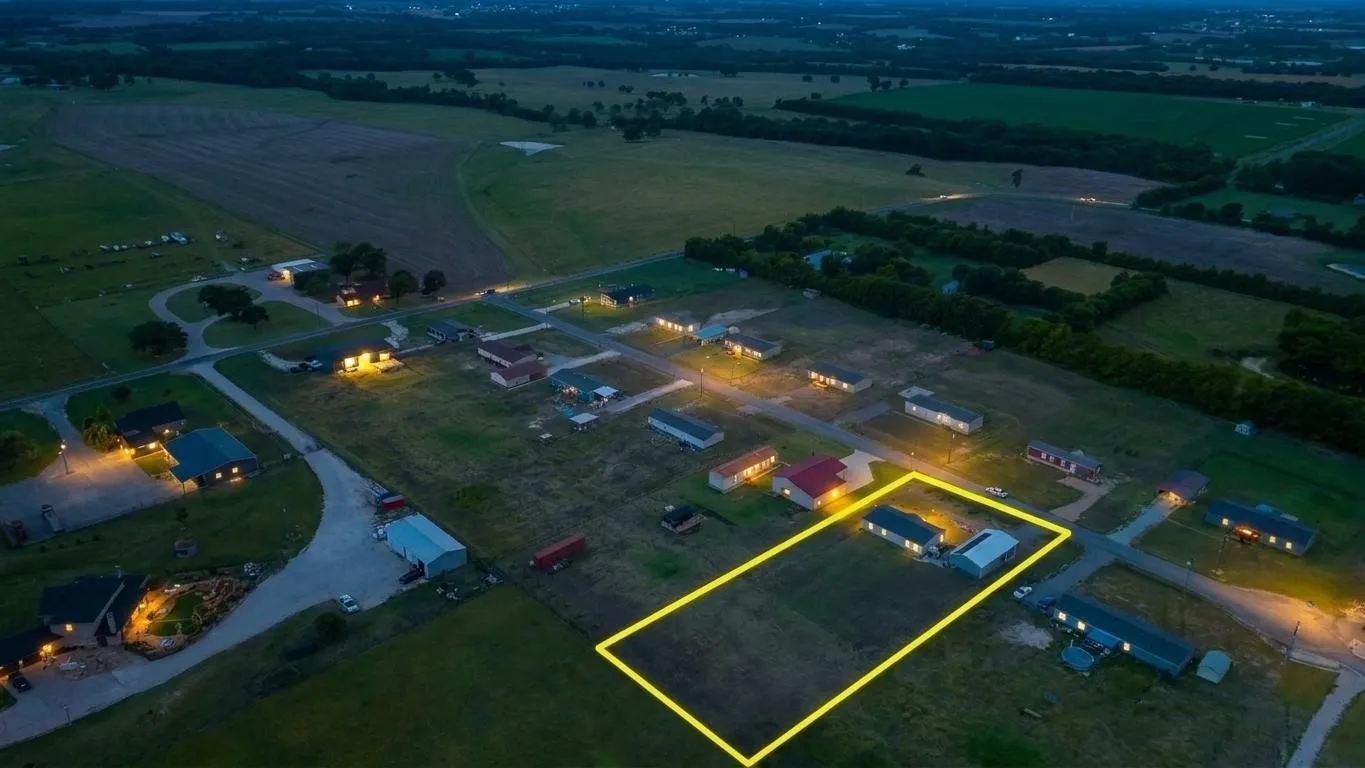 Aerial view of a residential property outlined in yellow, featuring a single-story structure and an adjacent outbuilding