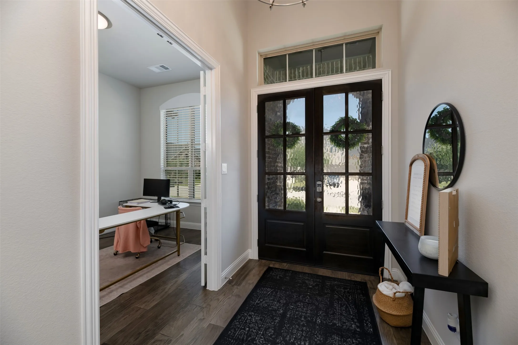 Entryway featuring dark wood-finish double doors with textured glass panels and a transom window