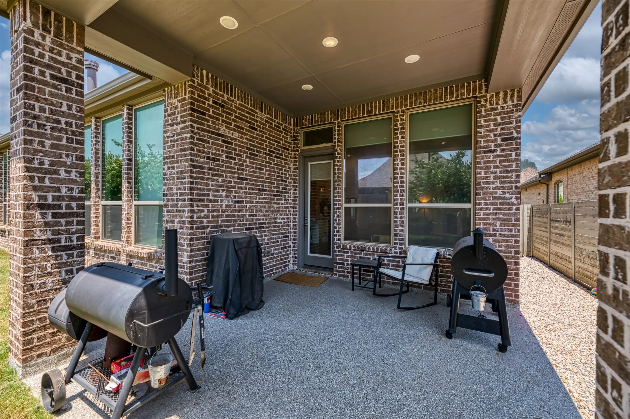 Covered patio featuring a granular-finish concrete surface and recessed lighting