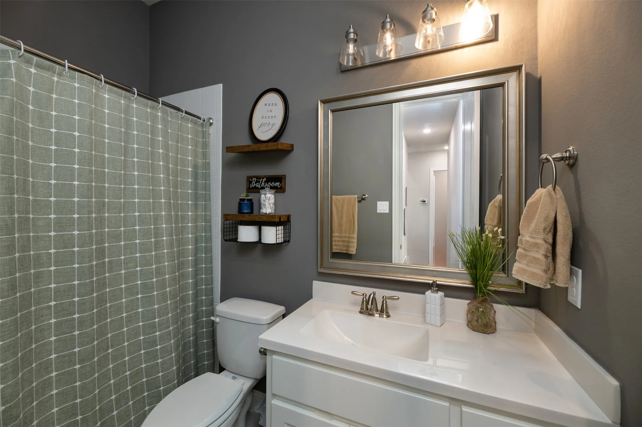 Bathroom featuring a single vanity with an integrated sink, polished chrome faucet, and a framed mirror