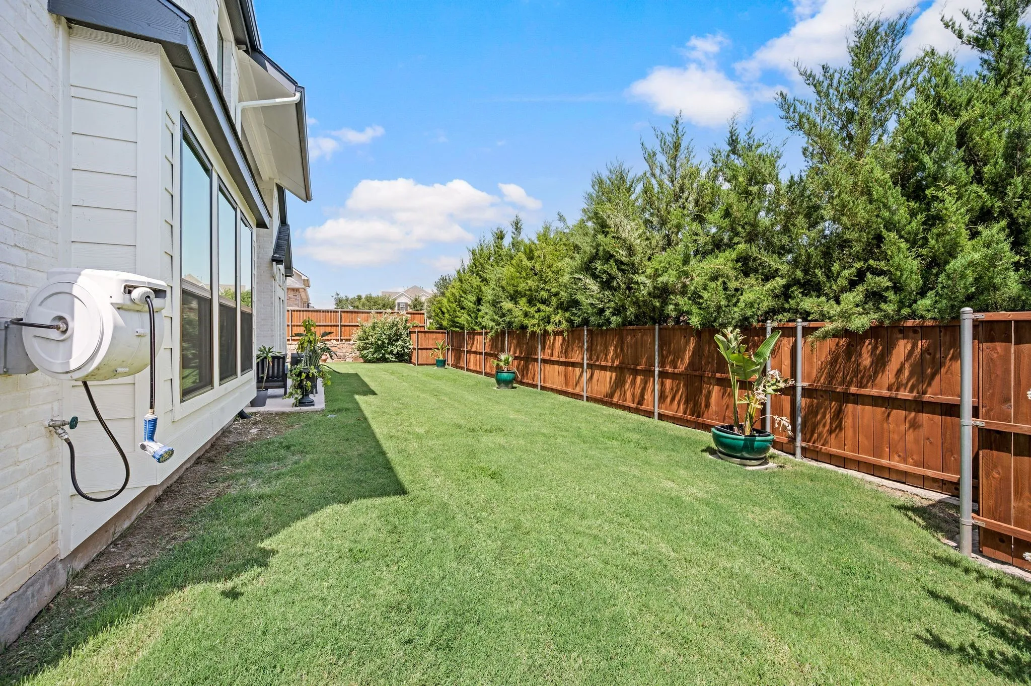 Yard wraps around each side of the home; Attached hideaway hose-reel conveys