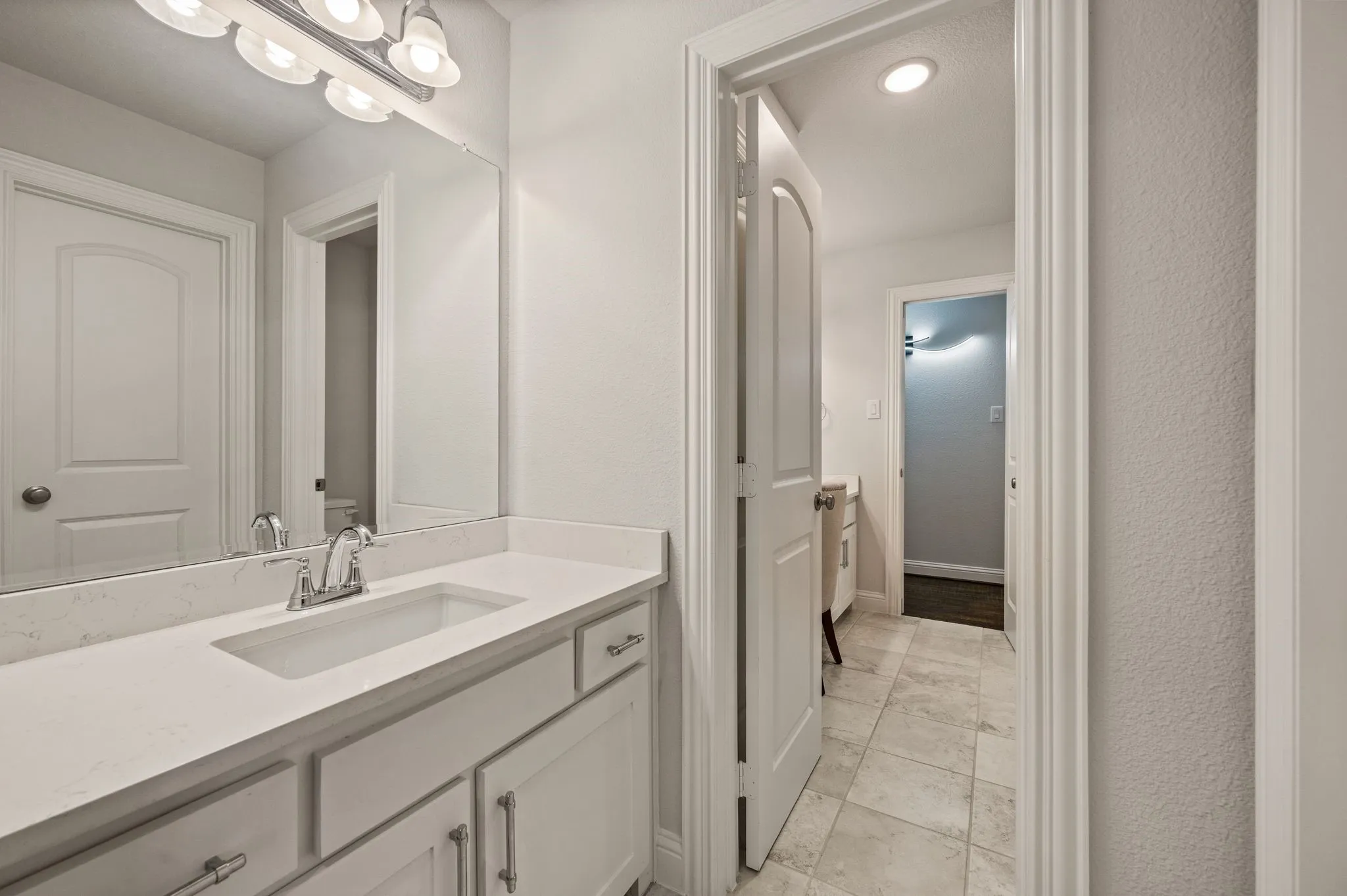 Hollywood-style bath has double closets and makeup vanity on one side; Quartz countertops