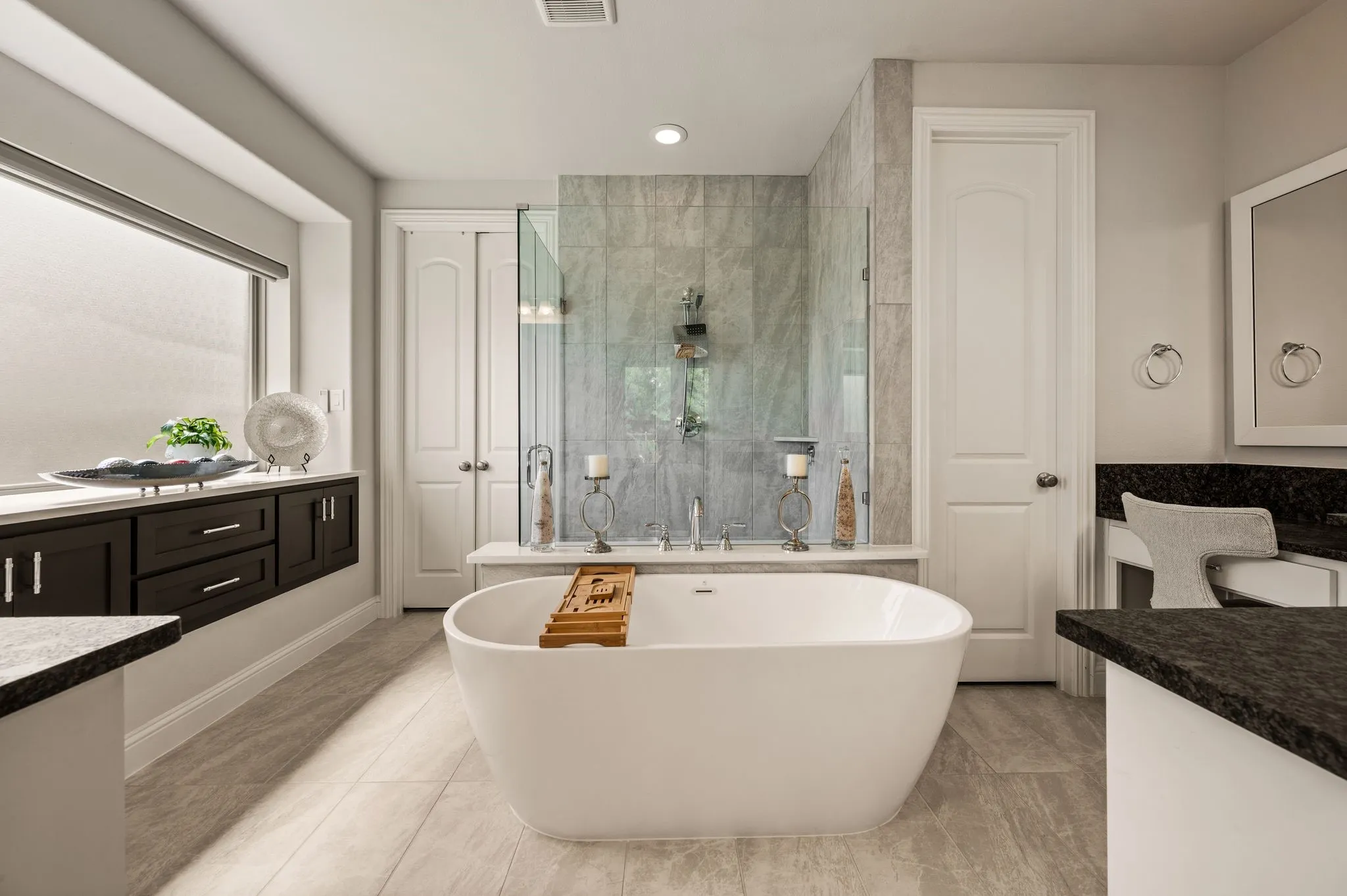 Primary bath has leathered granite; Separate sink-vanities; Doors to left are walk-in closet with wood shelving and under-stair panic or storage space; Door to right is water closet