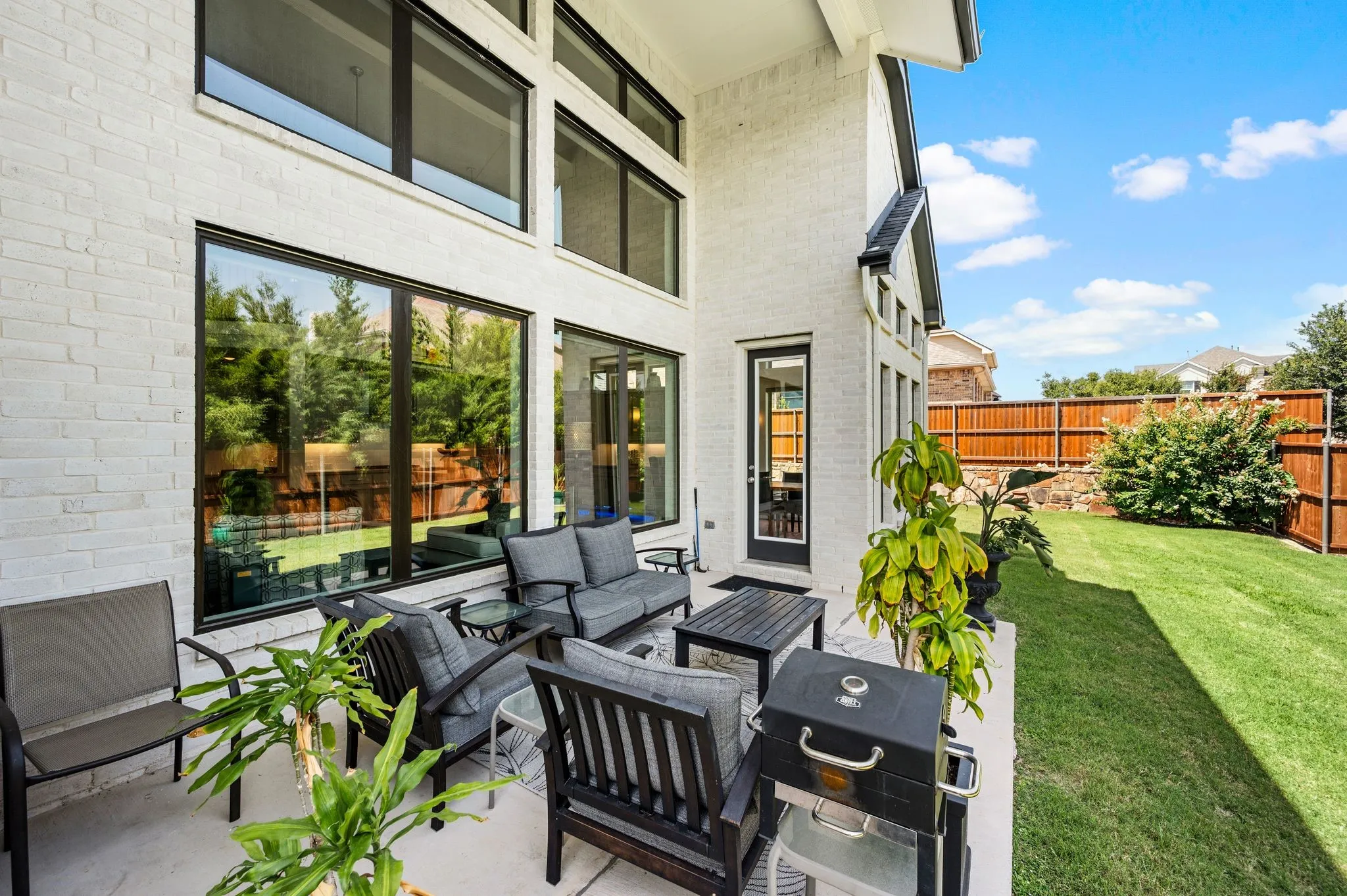 Rear Porch; 6-ft Wood fence atop the stone retaining wall creates additional privacy