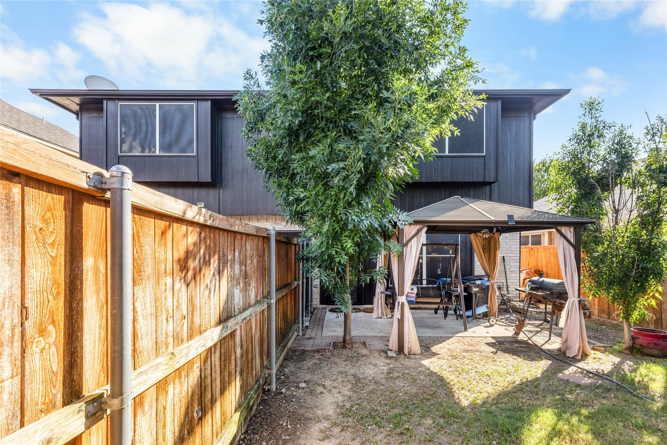 Private backyard featuring a paved patio area and a wooden privacy fence