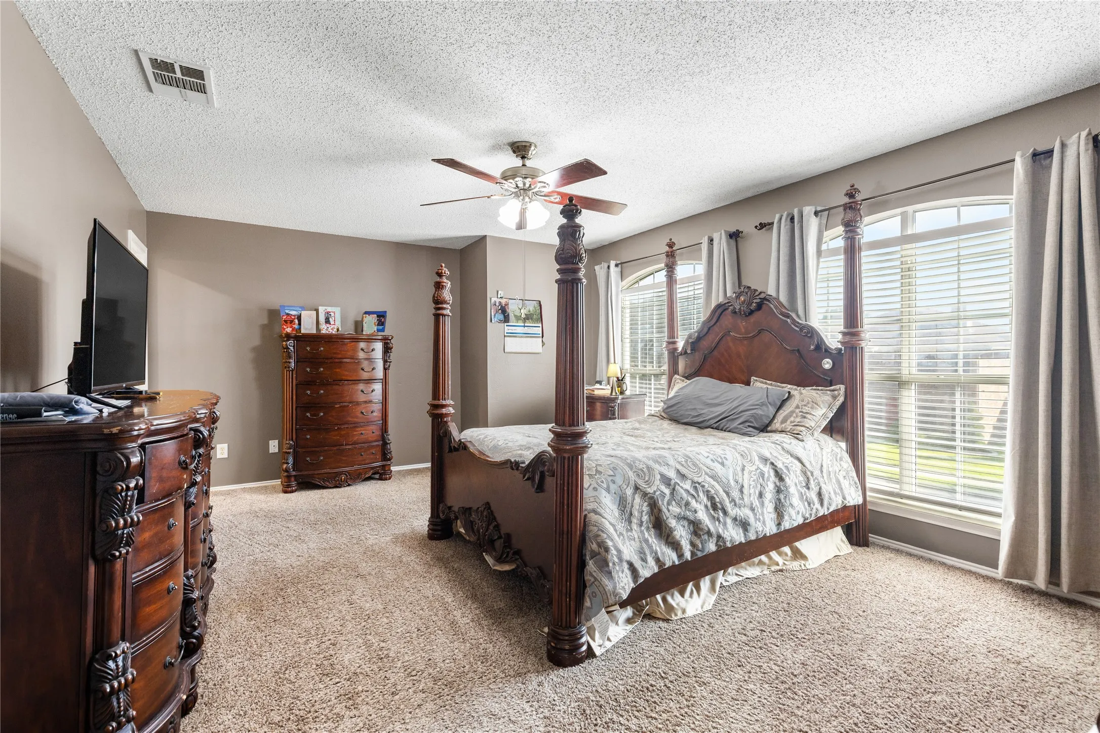 Carpeted bedroom with neutral wall tones and a textured ceiling