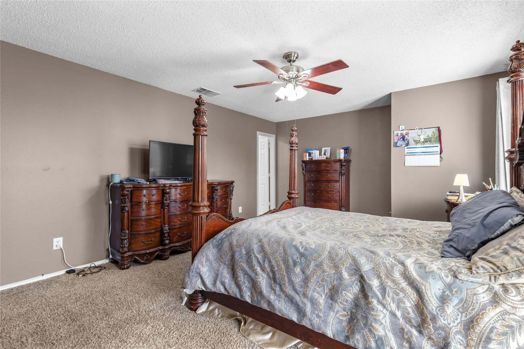 Carpeted room featuring neutral wall paint, a ceiling fan with light fixture, and white trim
