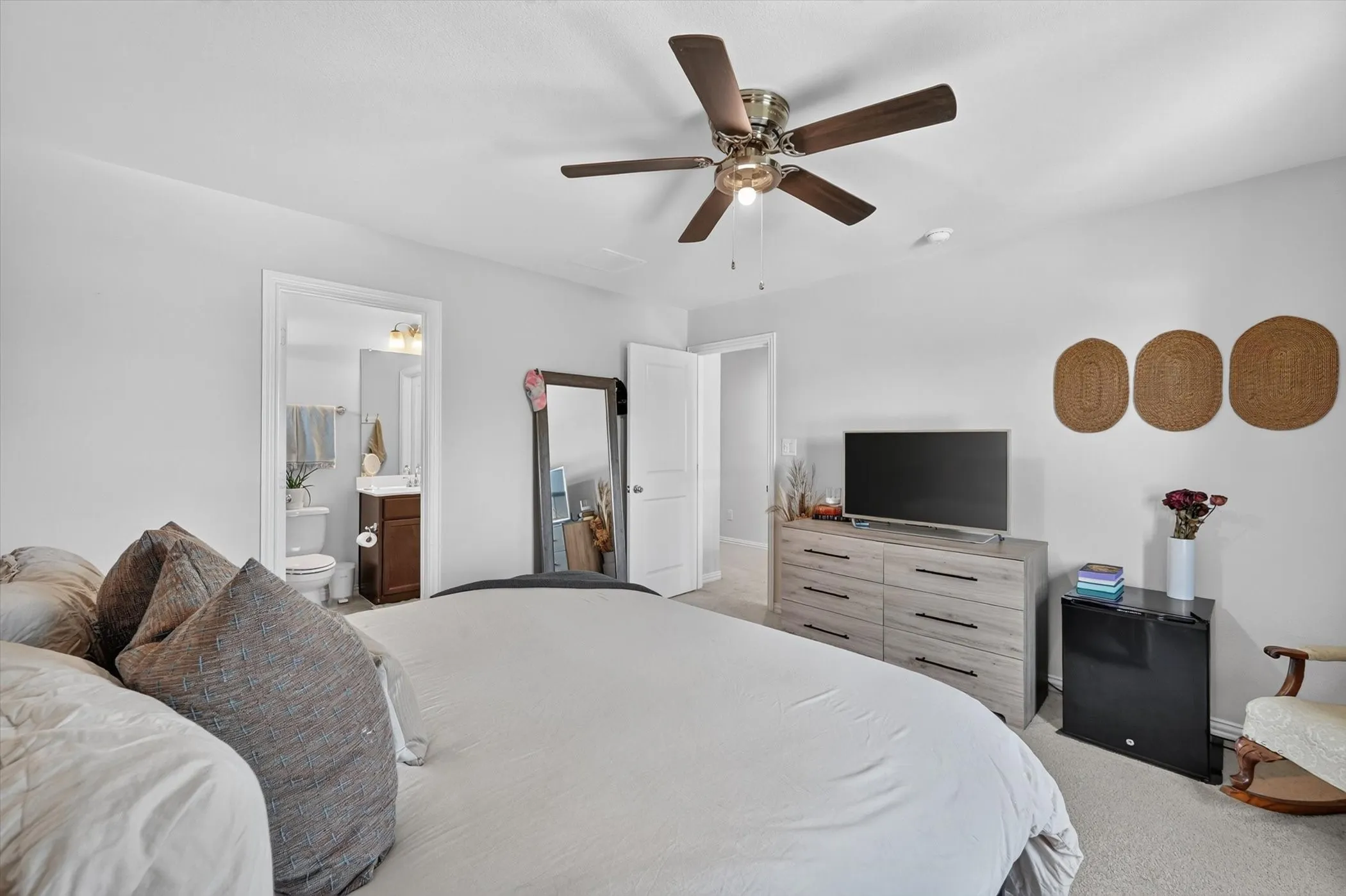 Carpeted bedroom with a ceiling fan