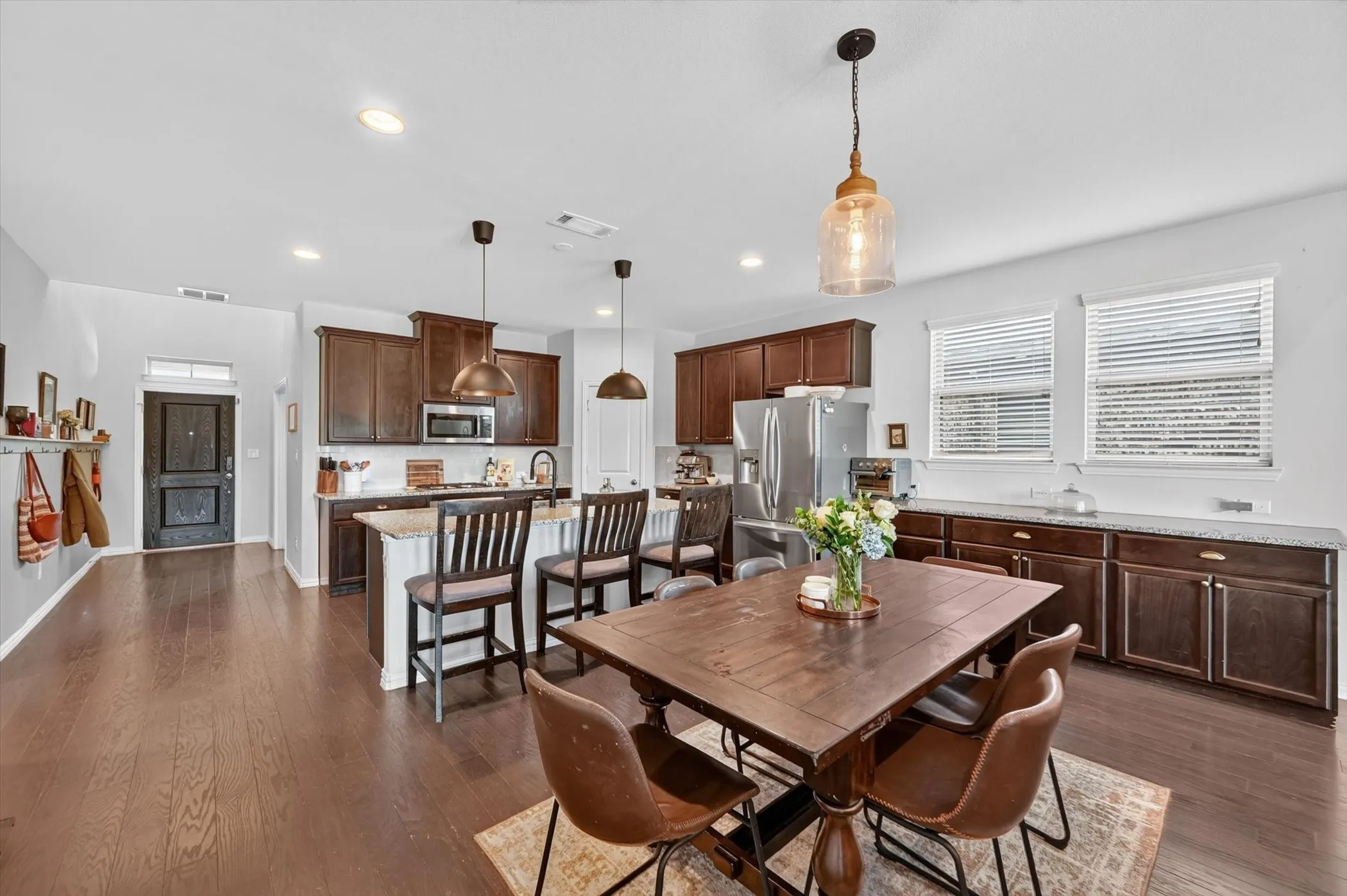 Open-concept floorplan featuring wood-finish flooring, recessed lighting, and a kitchen island with seating