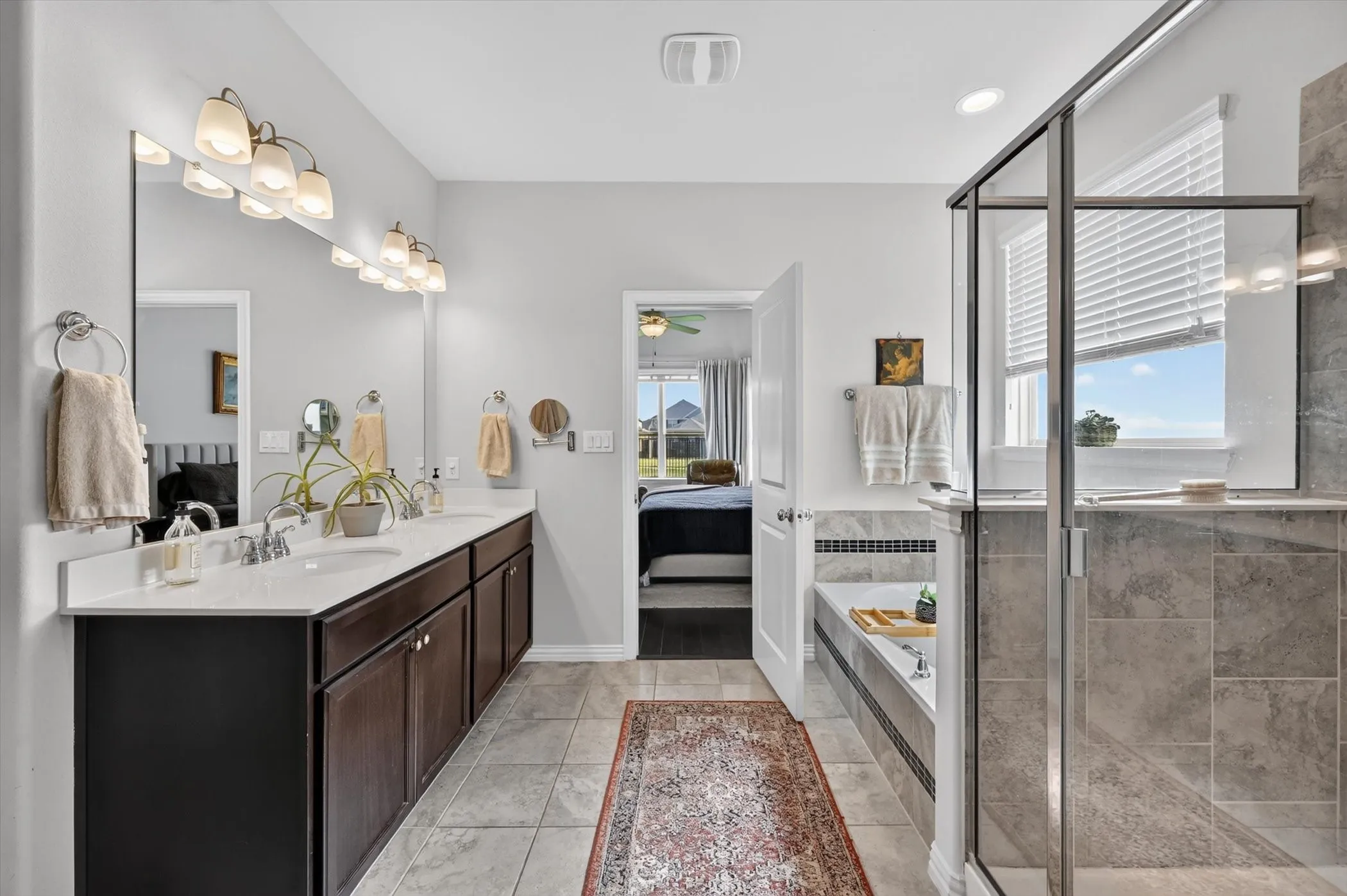 Dual vanity with white countertops and dark wood cabinetry