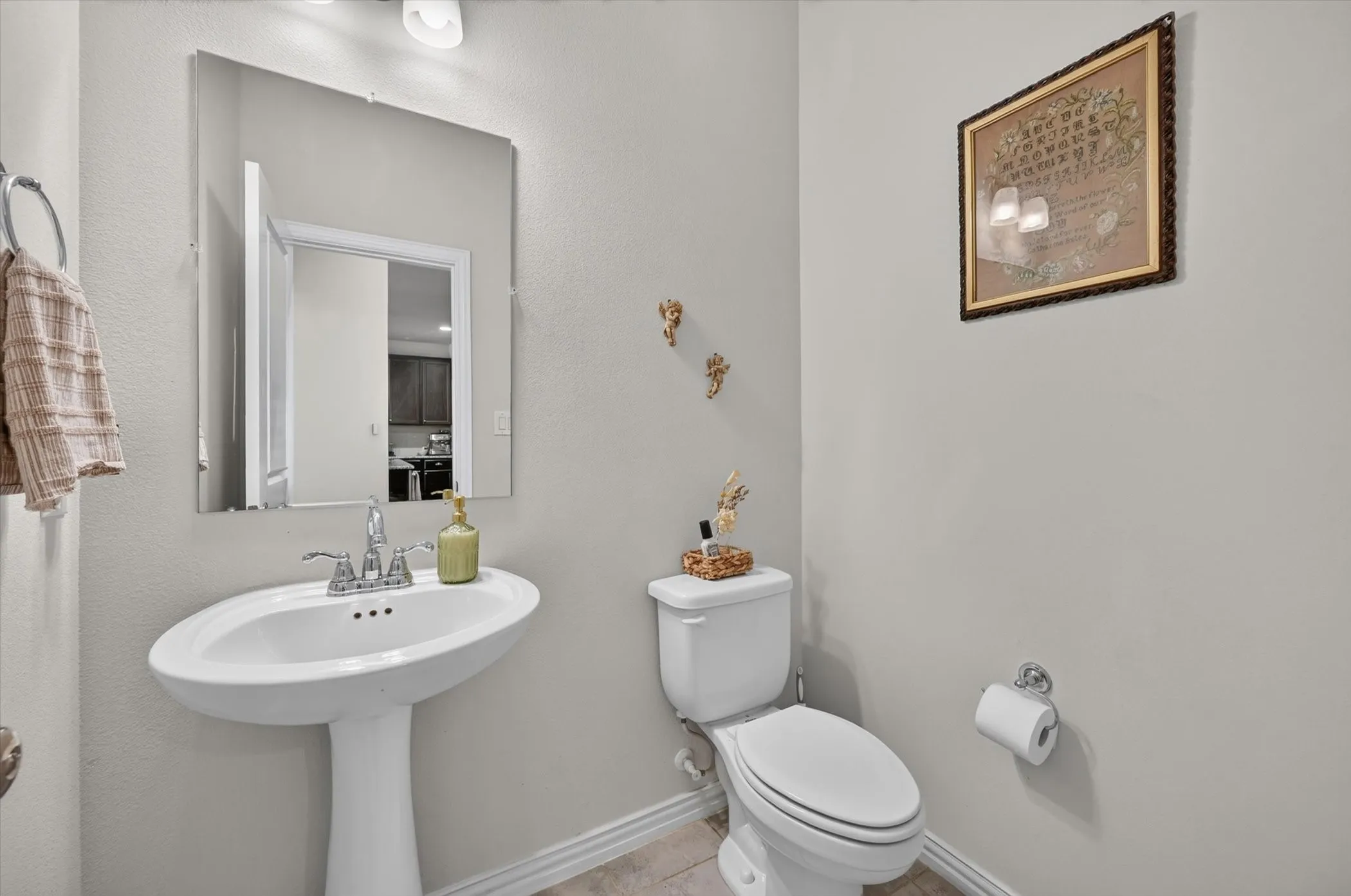 Pedestal sink with chrome faucet, complemented by a white toilet