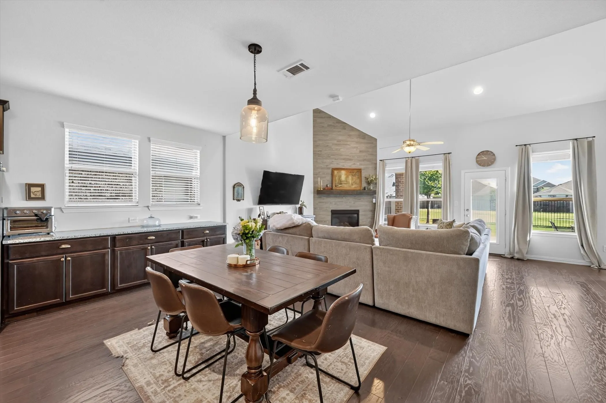 Open-concept living area featuring rich wood-finish flooring and a vaulted ceiling