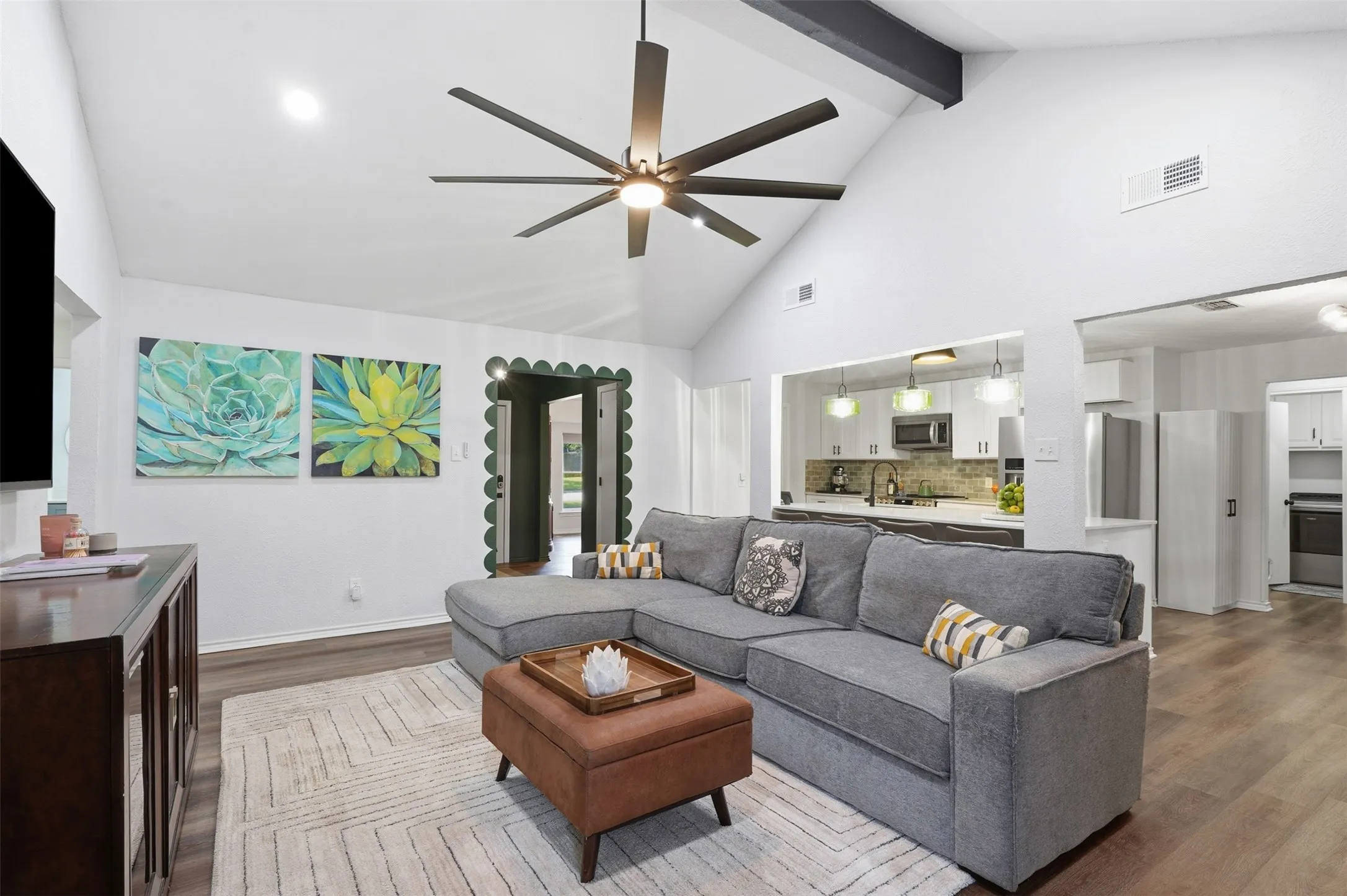 Vaulted ceilings with open floor plan, leading to kitchen, dining, and sunroom.