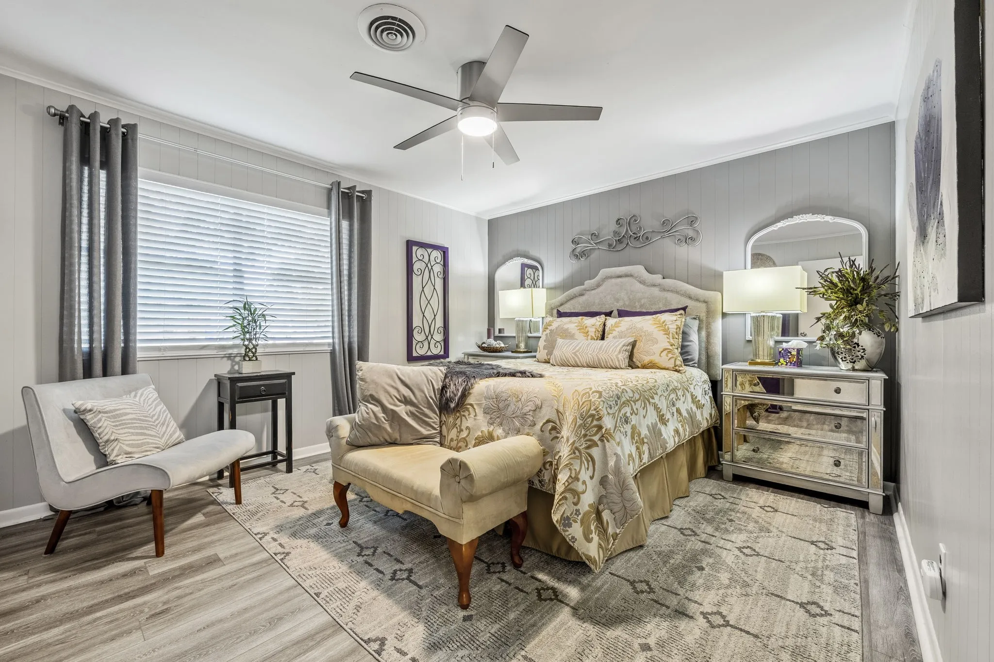 Bedroom featuring wood-finish flooring, a ceiling fan with integrated lighting, and a window with blinds and curtain rods