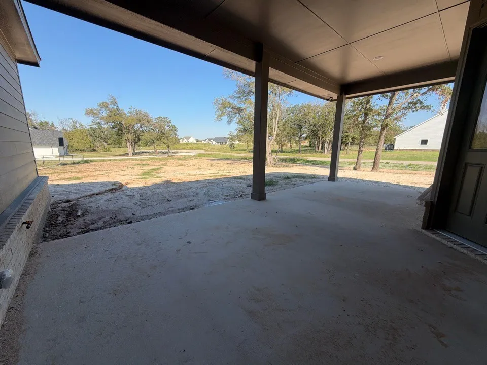 Covered patio with concrete flooring and multiple support columns
