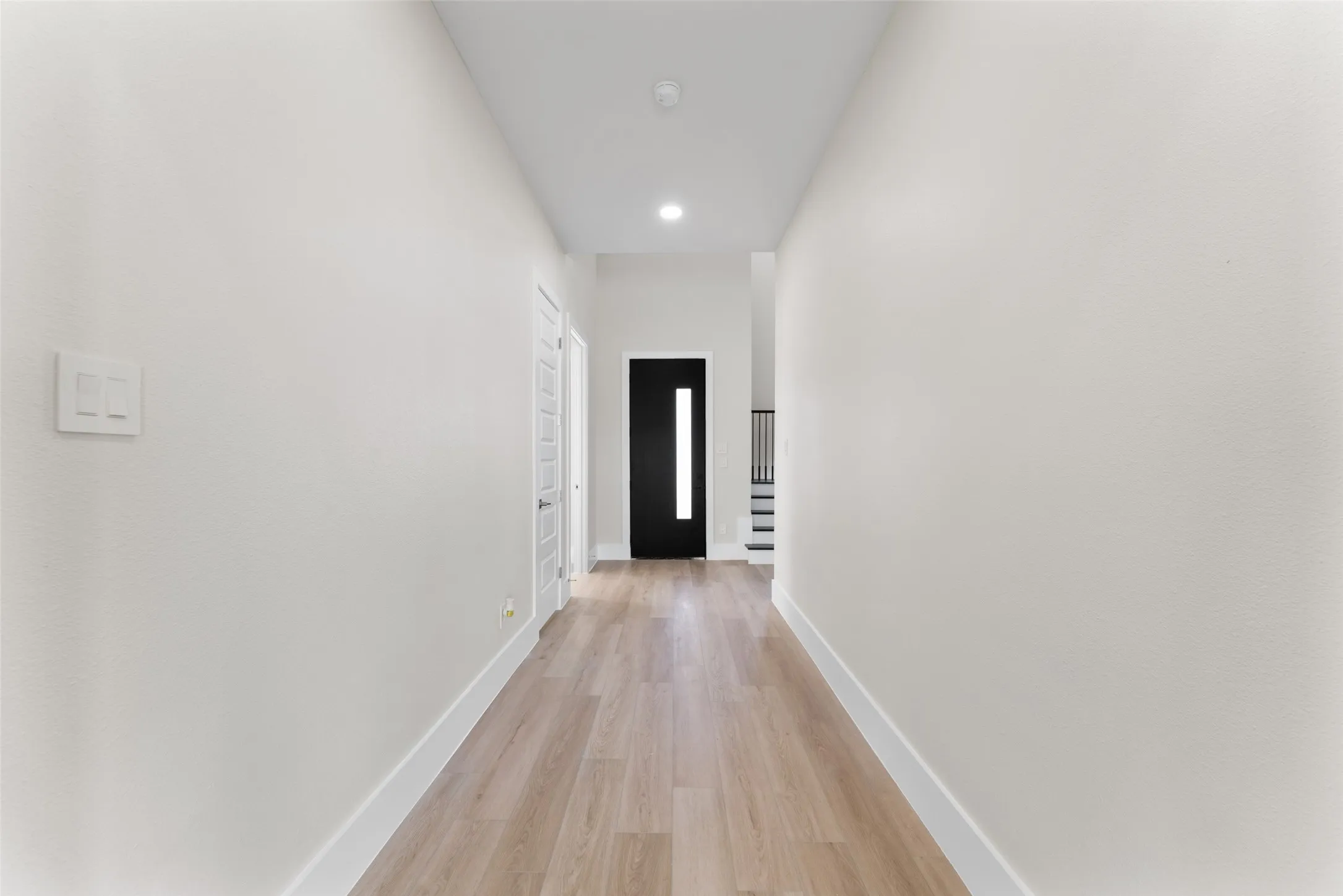 Corridor featuring light wood-type flooring and recessed lighting