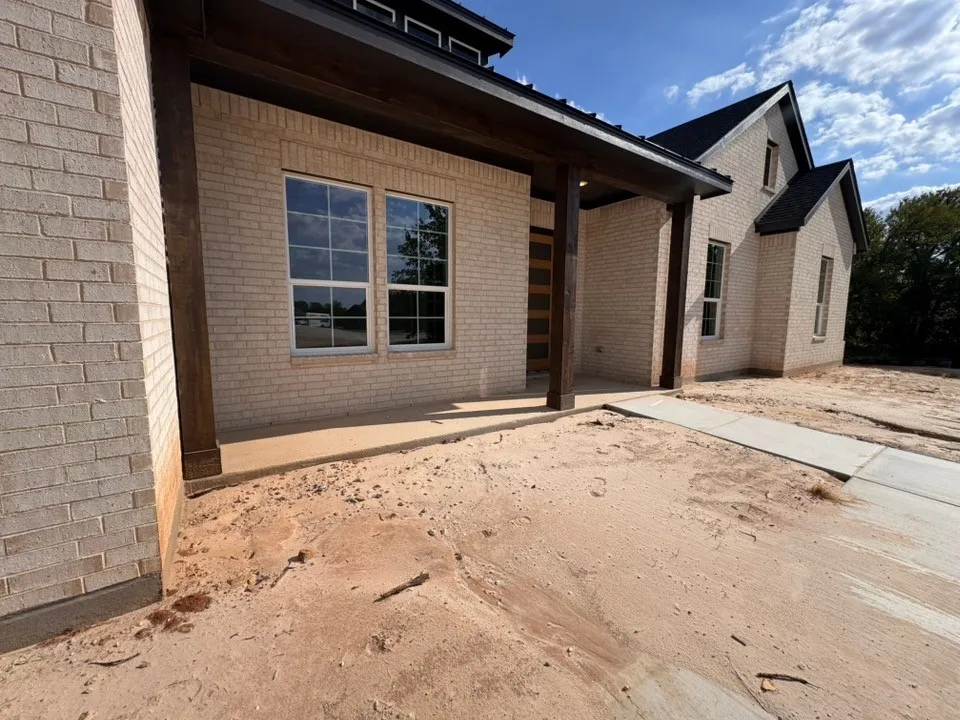 Brick exterior with dark trim and a prominent covered entry