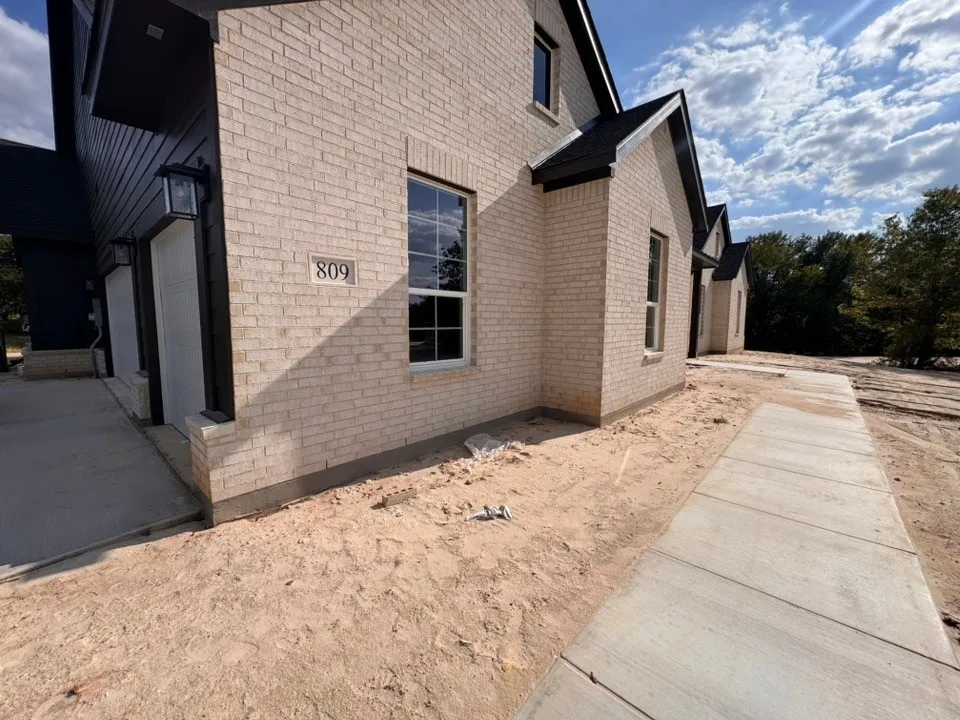 Light-toned brick exterior with dark trim and a gabled roofline