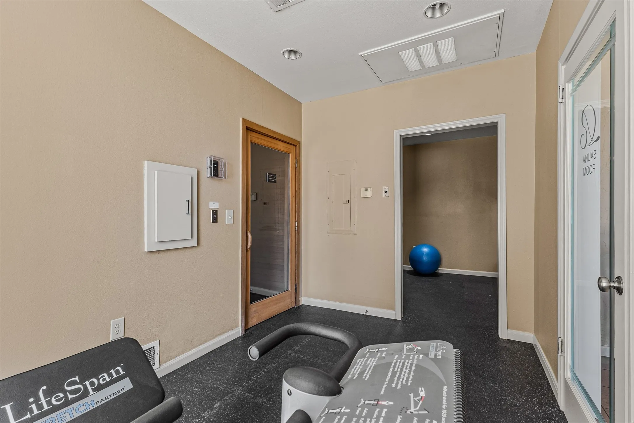 Interior space featuring light tan walls and dark rubber flooring