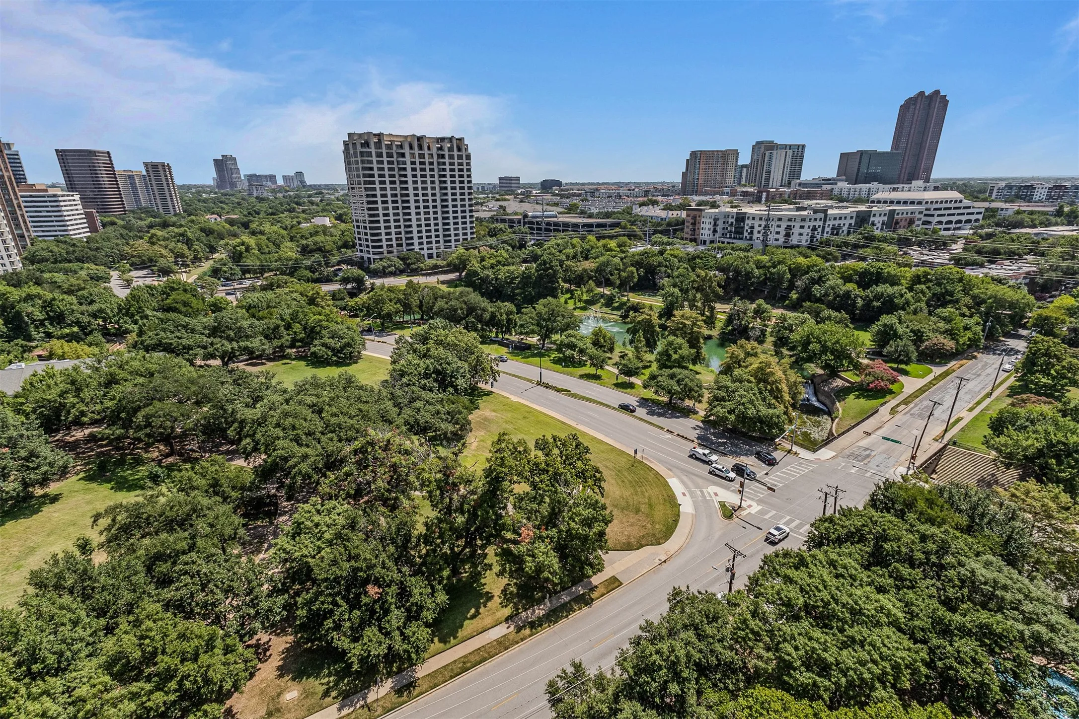 Expansive cityscape featuring multiple high-rise buildings and verdant parkland