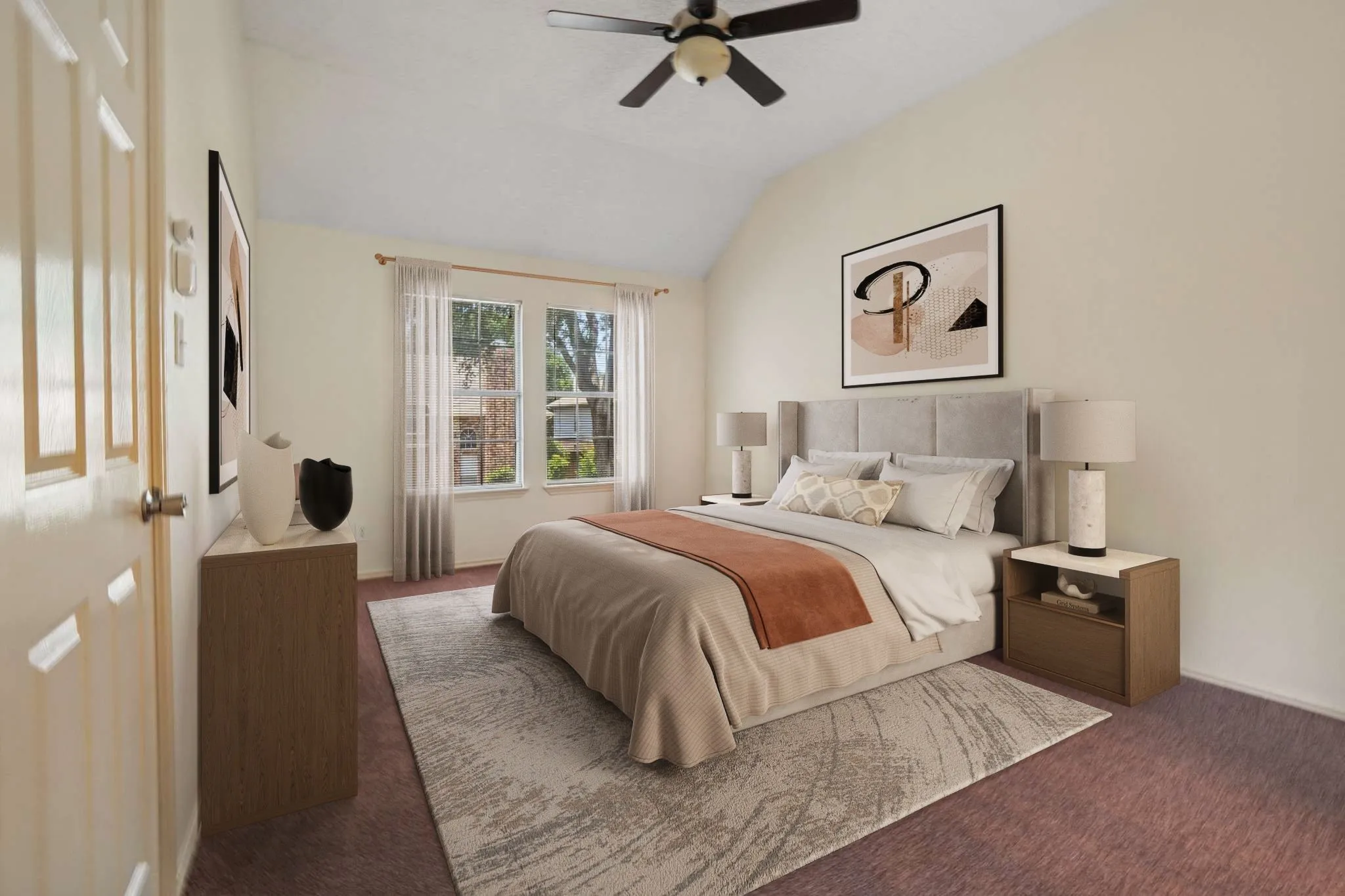 Vaulted ceiling bedroom featuring plush carpeting, a ceiling fan with light fixture, and two large window panes with sheer white curtains