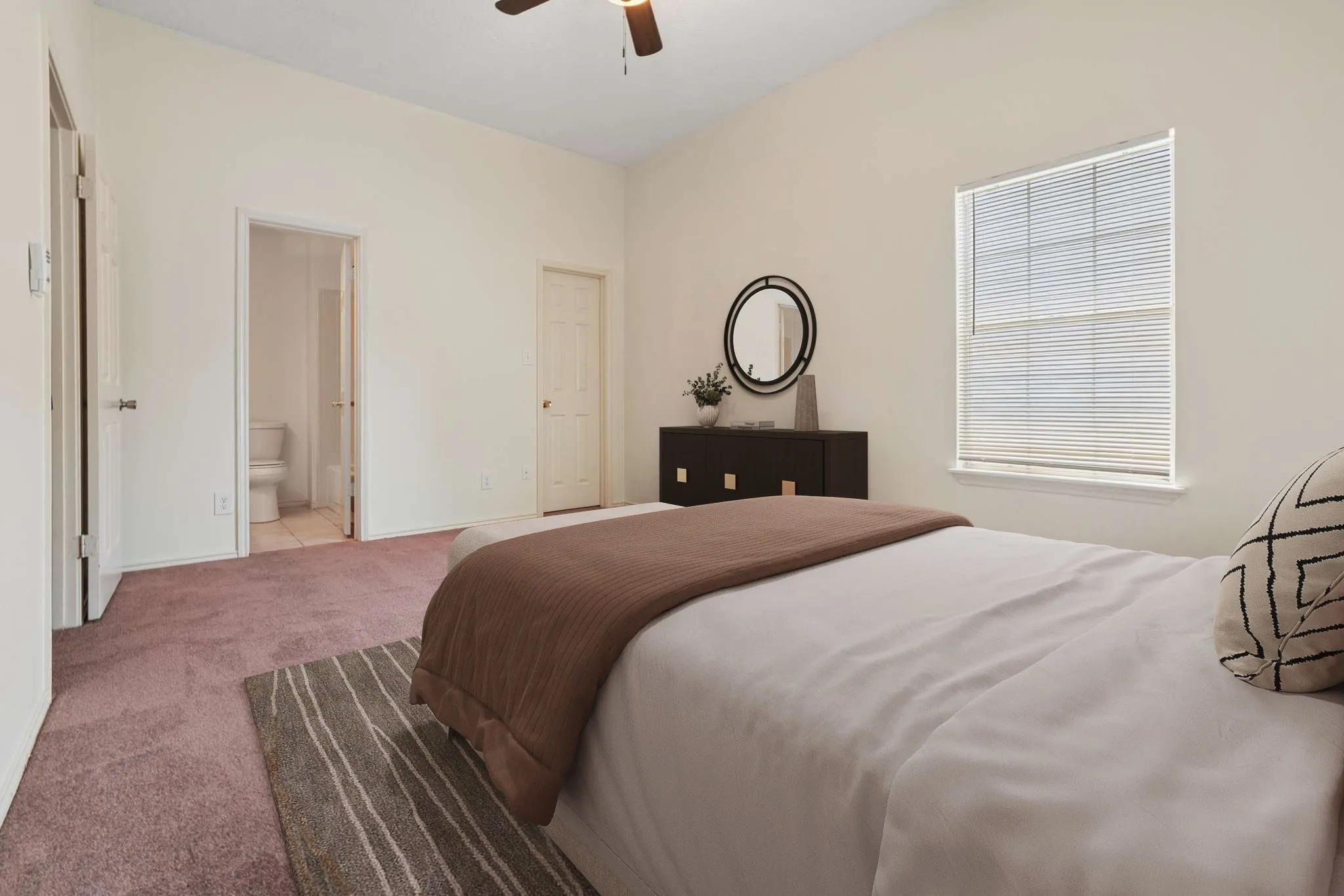 Carpeted bedroom featuring an angled ceiling and a ceiling fan