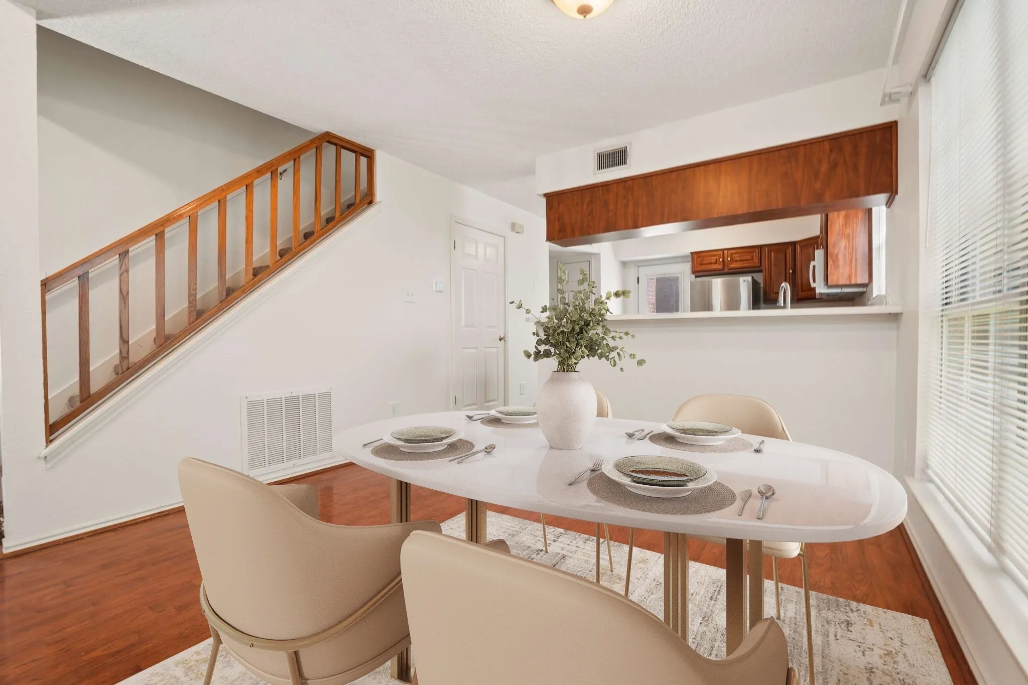 Dining area featuring wood-finish flooring and a pass-through window to the kitchen