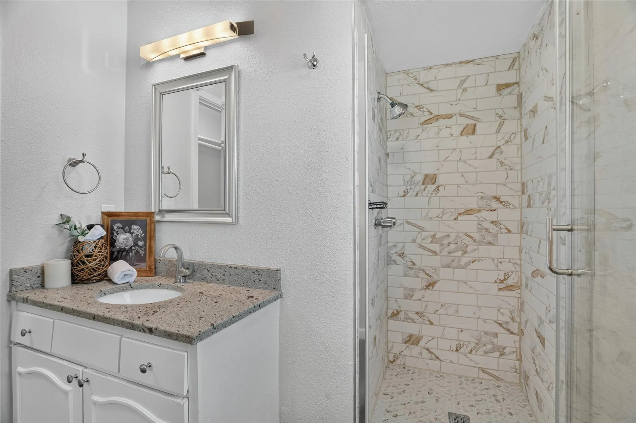 Bathroom featuring a shower with glass enclosure, subway tile walls, and a tiled floor