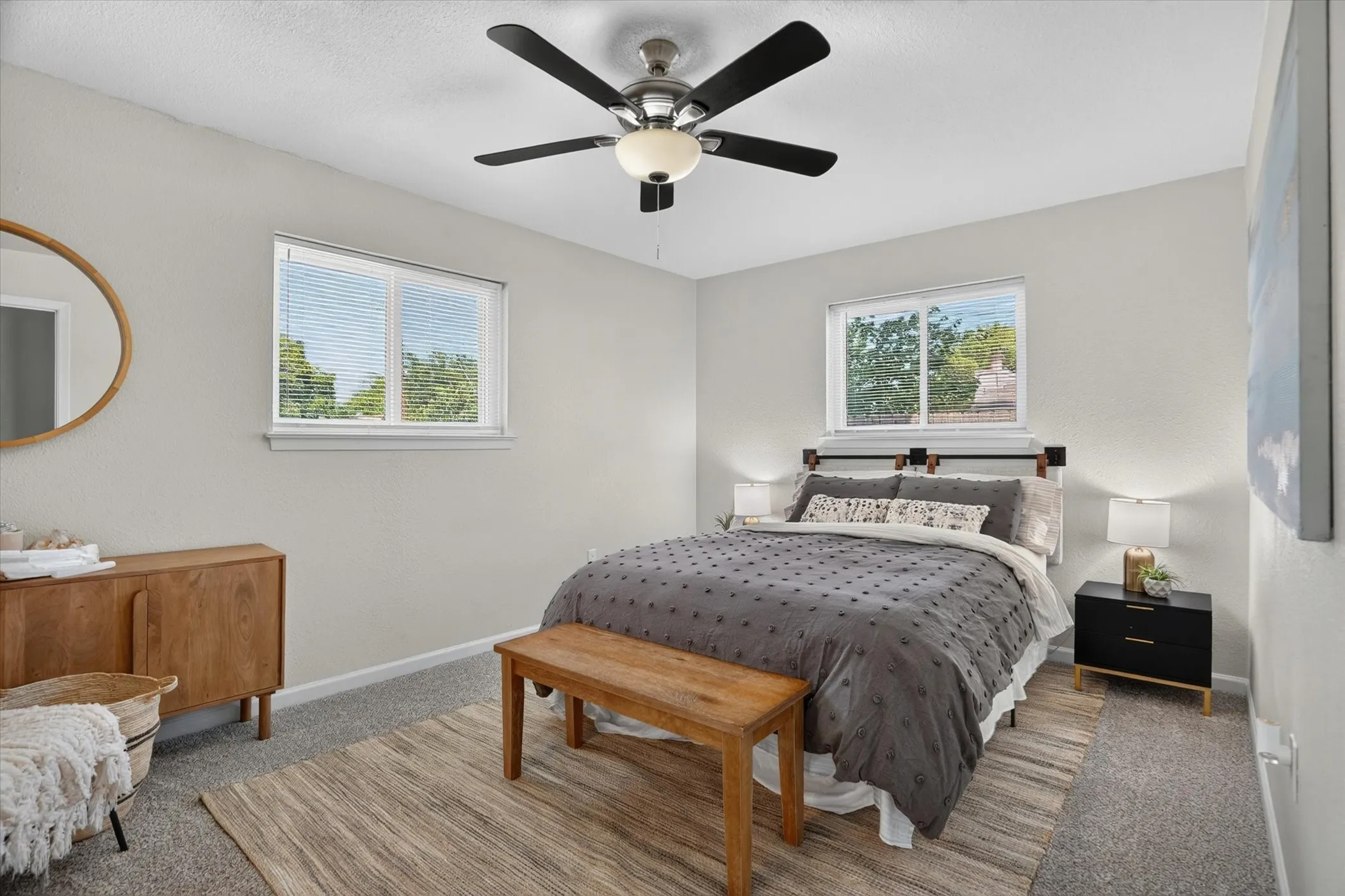 Bedroom featuring two windows with blinds, a ceiling fan with integrated lighting, and carpet flooring