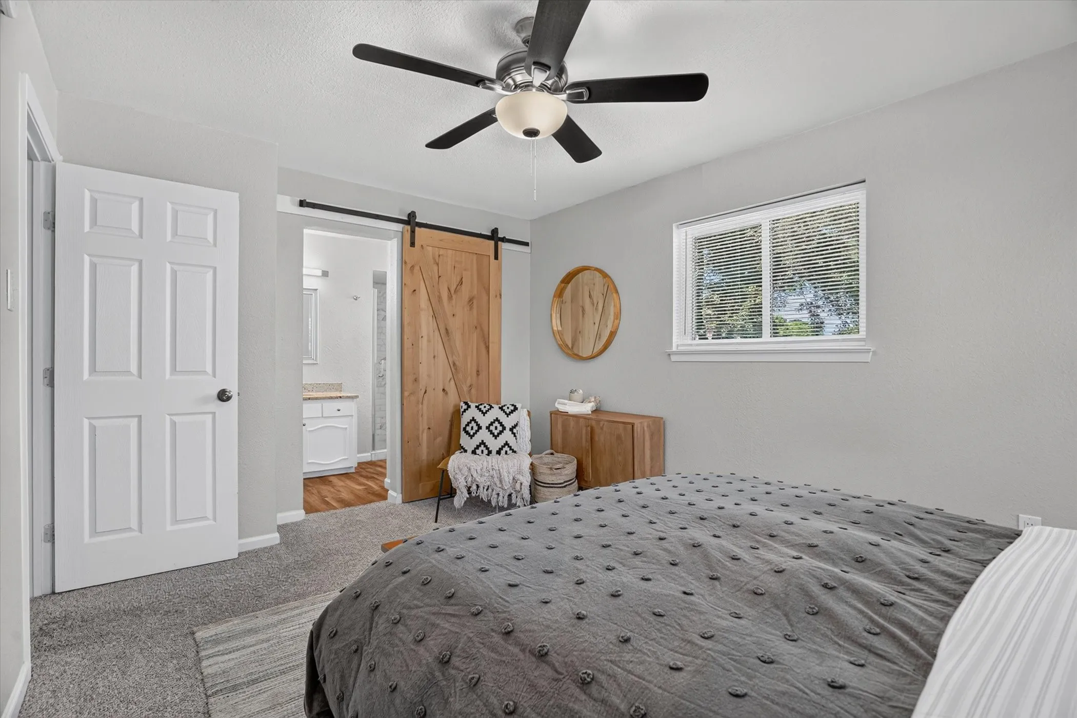 Bedroom featuring light gray walls, carpet flooring, and a ceiling fan with integrated lighting