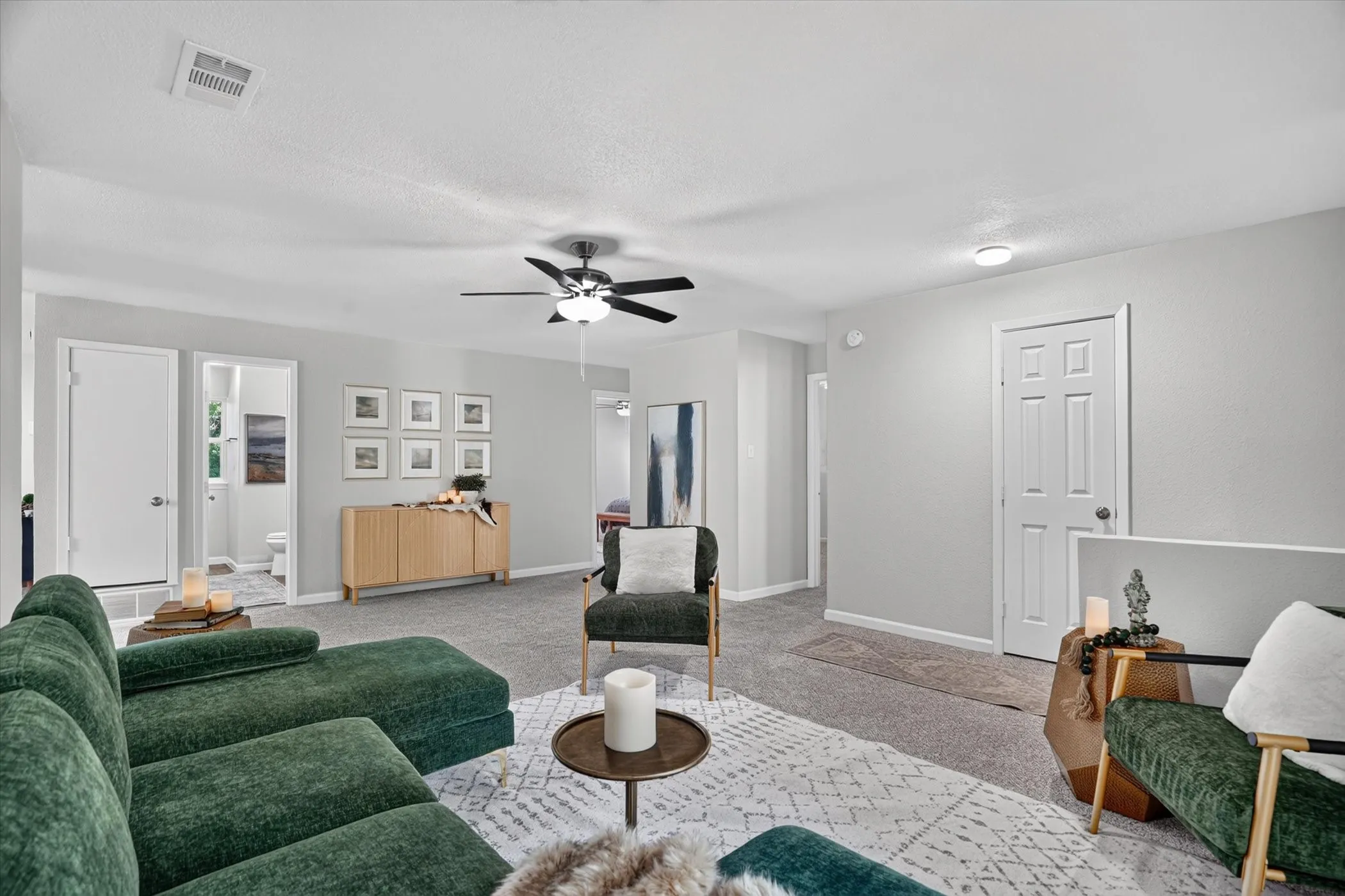Expansive living area with light gray walls and carpet flooring