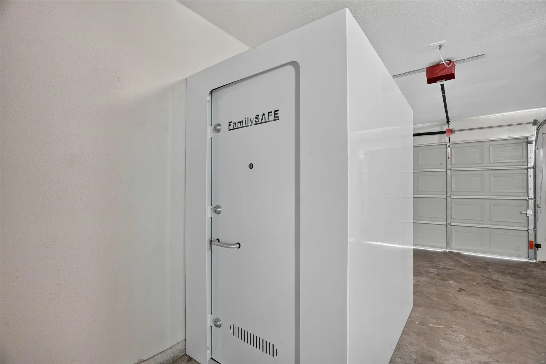 Dedicated garage space featuring a secure room with a reinforced door and multiple locking points
