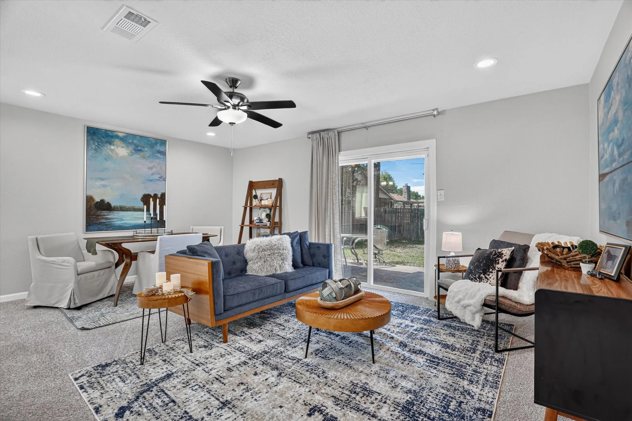 Spacious living area featuring light gray walls, recessed lighting, and soft gray carpeting