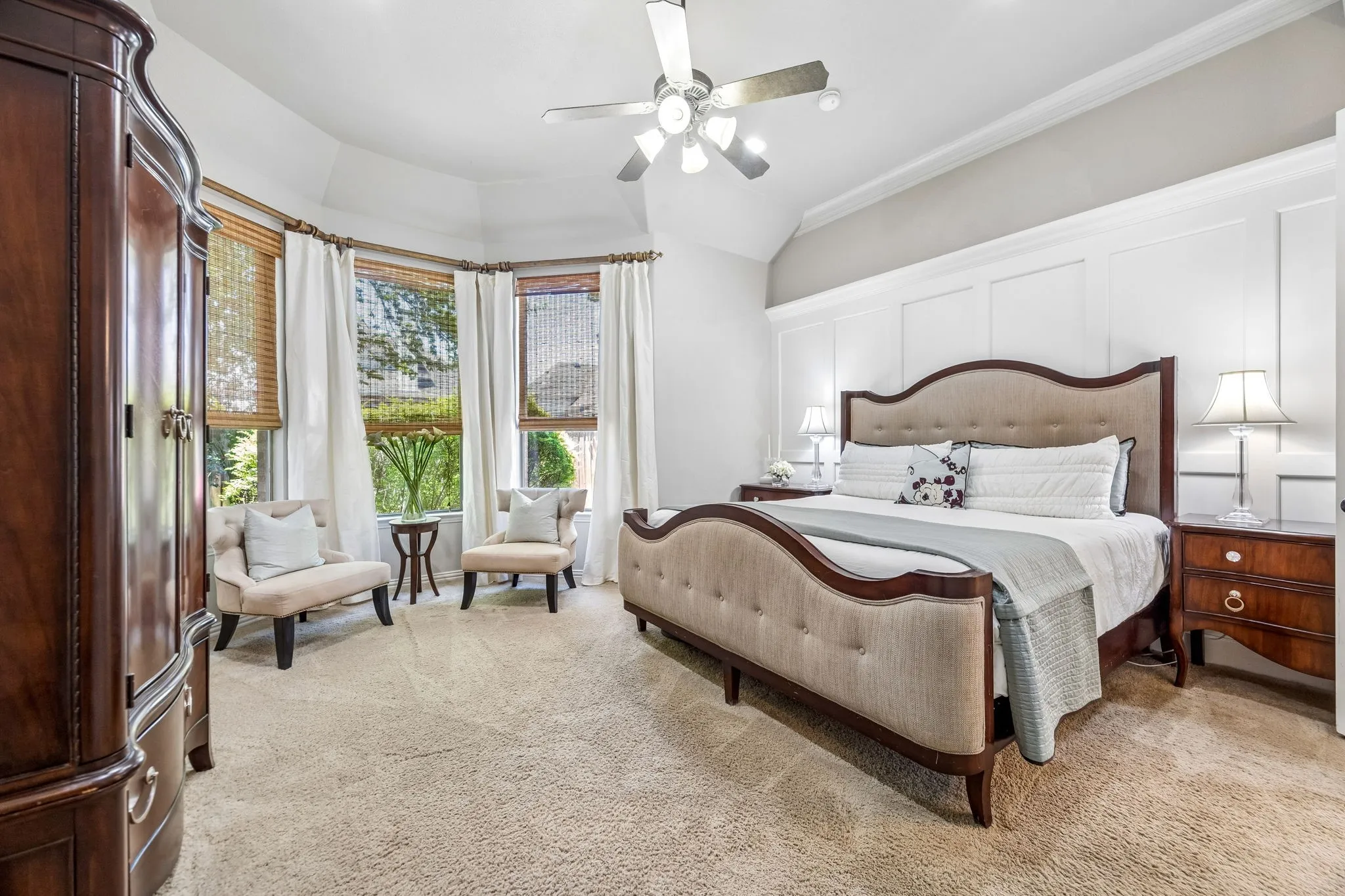 Primary suite on first floor with crisp white wainscoting