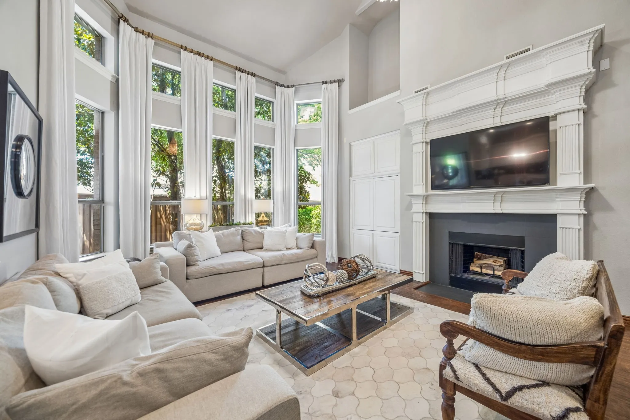 Soaring living room ceiling with tree lined backyard views