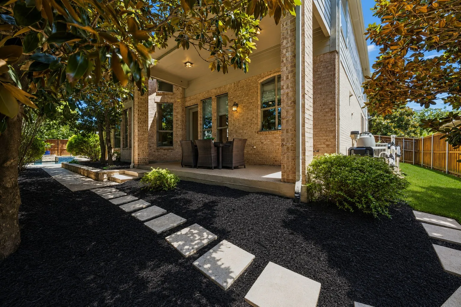 Charming patio with shade and walkway to pool and yard space