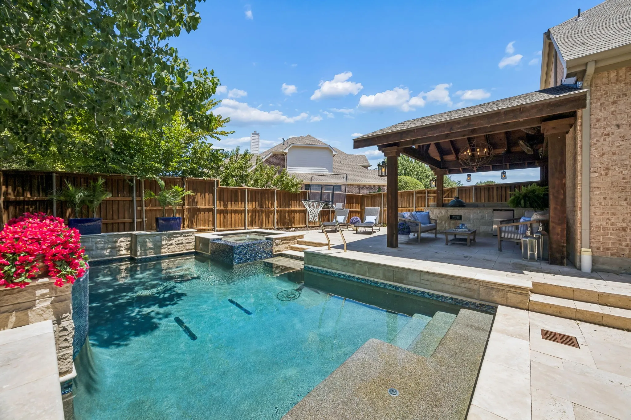 Backyard resort with sparkling pool, spa, and covered patio with barbeque