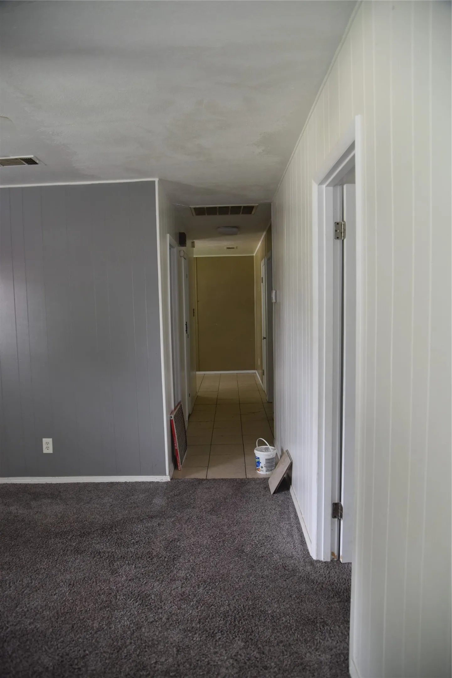Hallway featuring a tiled floor and multiple doorways