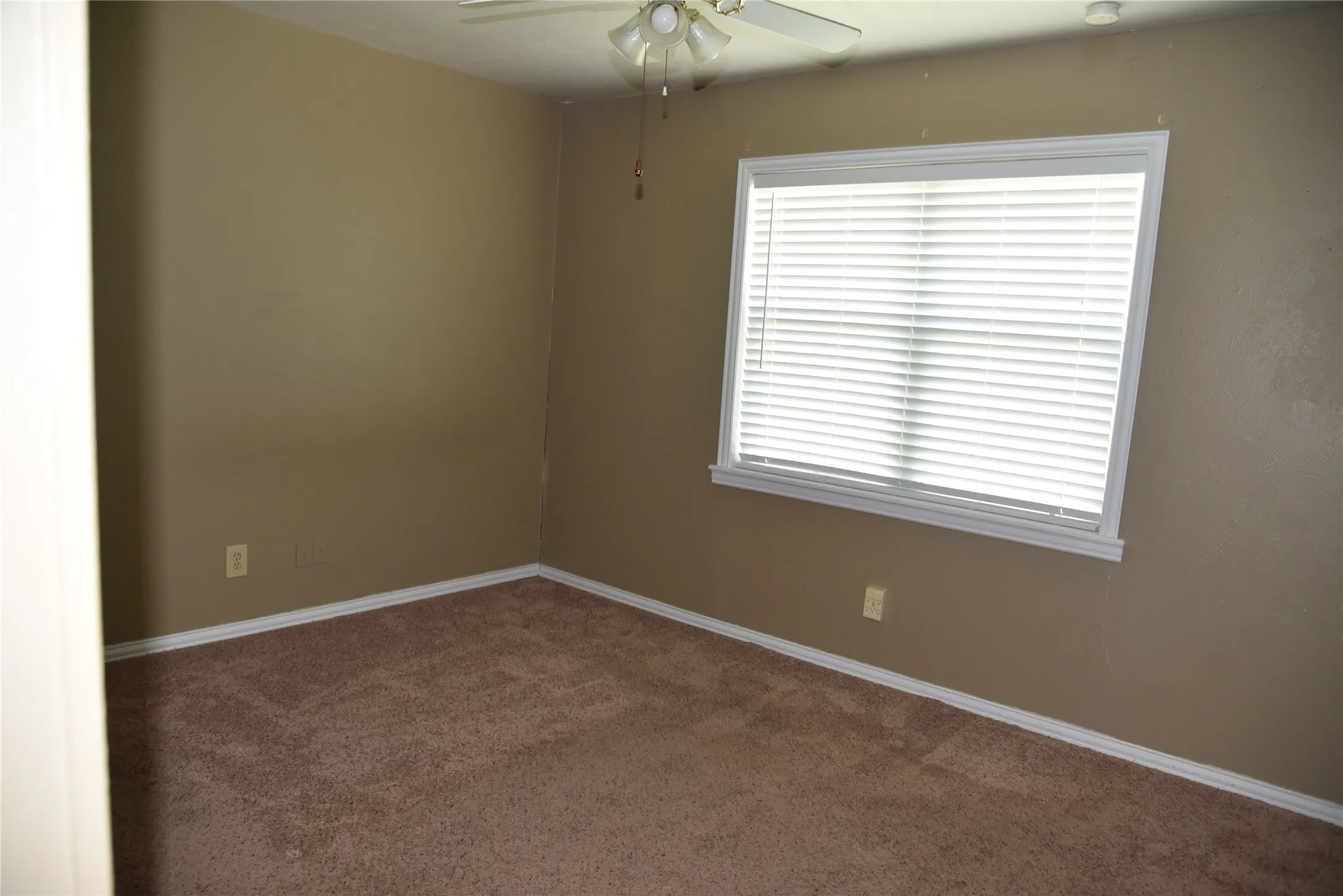 Bedroom featuring carpet flooring, neutral-toned walls, and a window with horizontal blinds