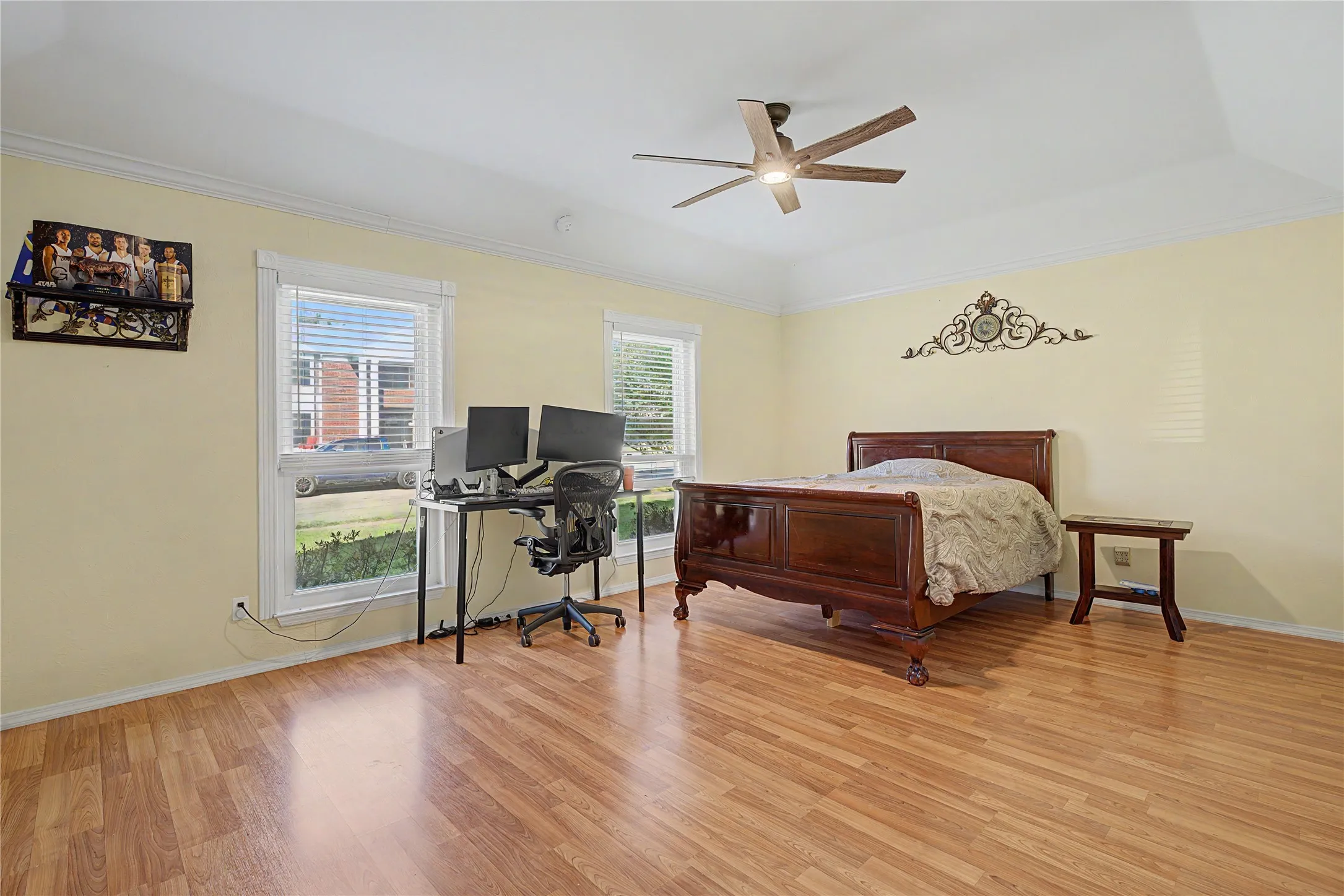 Tray ceiling with crown molding, wood-finish flooring, and multiple windows