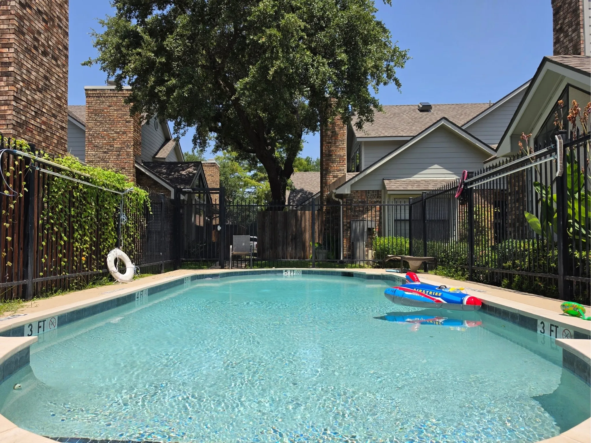 Sparkling swimming pool featuring a curved perimeter, tiled interior, and visible depth markings