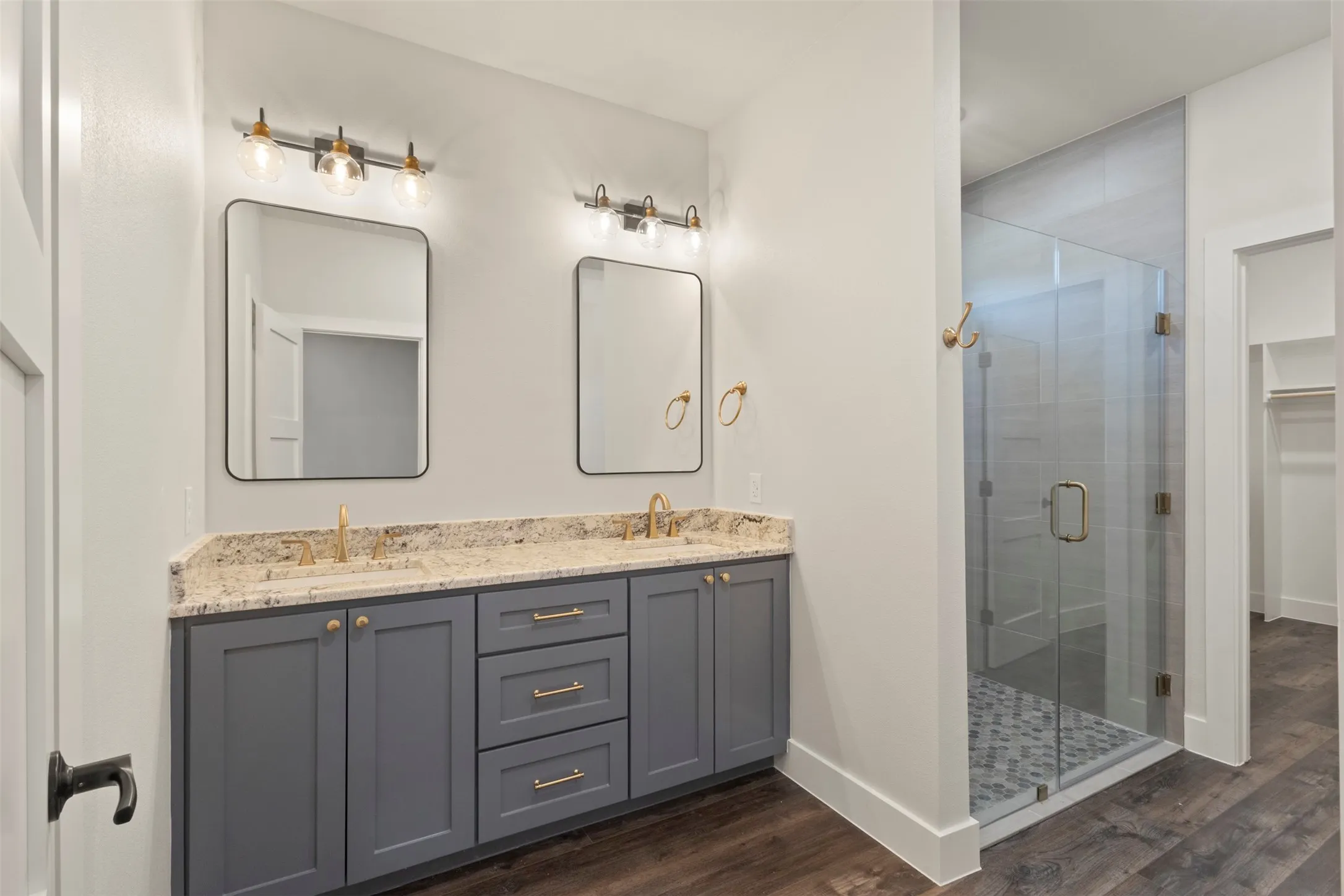 Dual vanity with granite countertop, undermount sinks, and gold-finish faucets