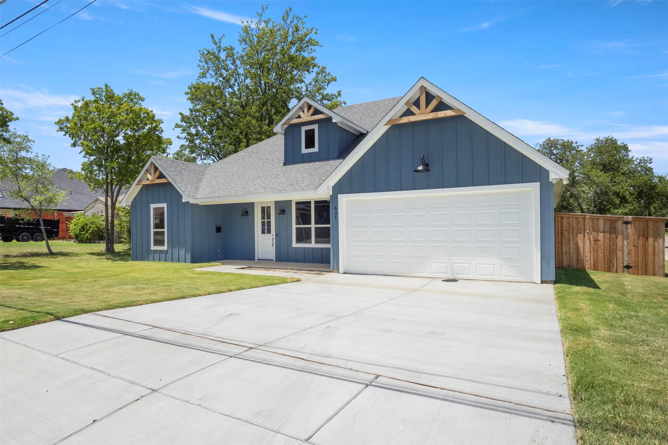 Craftsman-inspired exterior featuring board and batten siding, a white garage door, and a concrete driveway