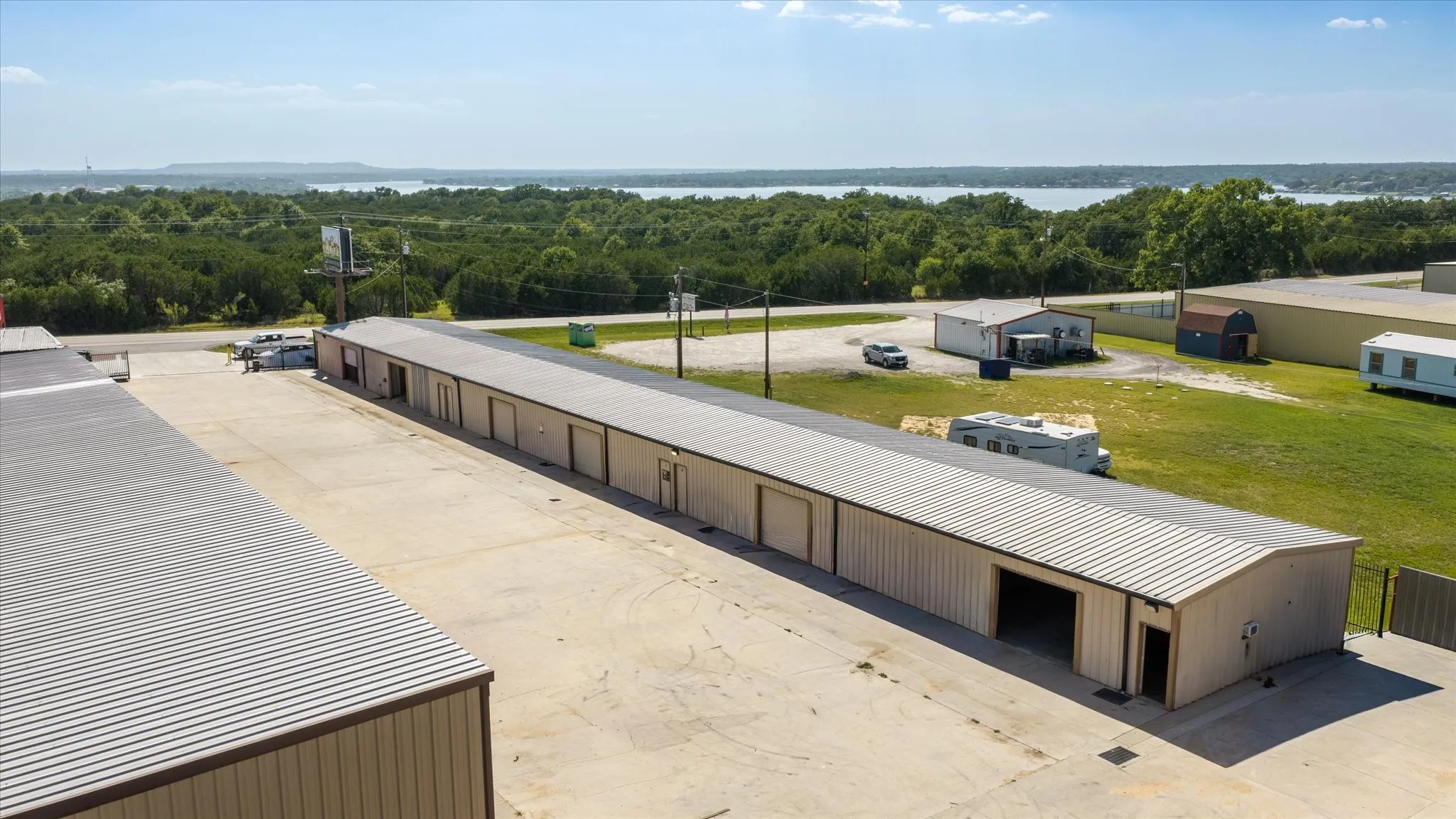 Commercial property featuring multiple single-story metal buildings with roll-up doors and a large concrete drive