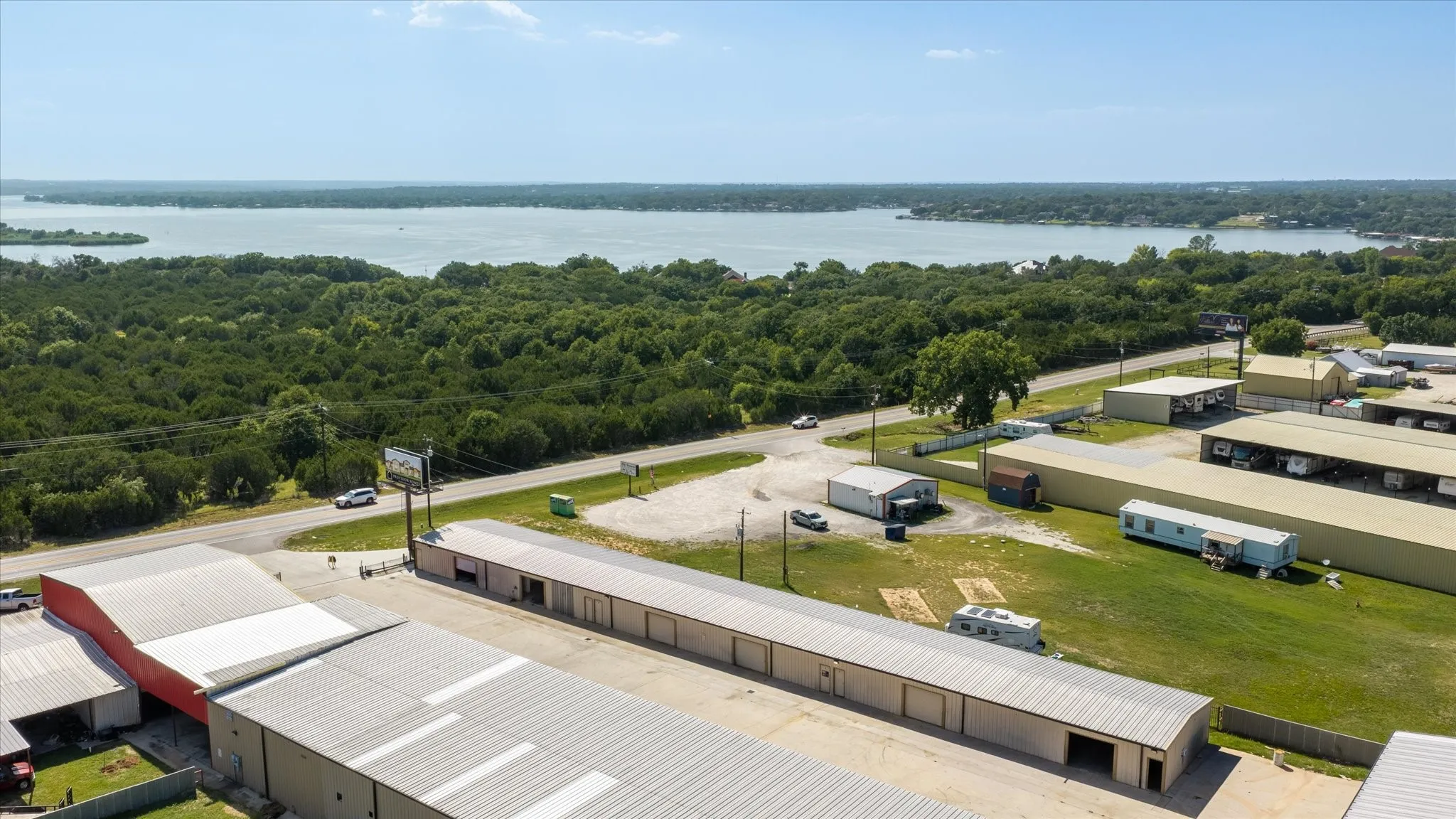Aerial perspective showcasing multiple commercial structures with metal roofing and a paved road