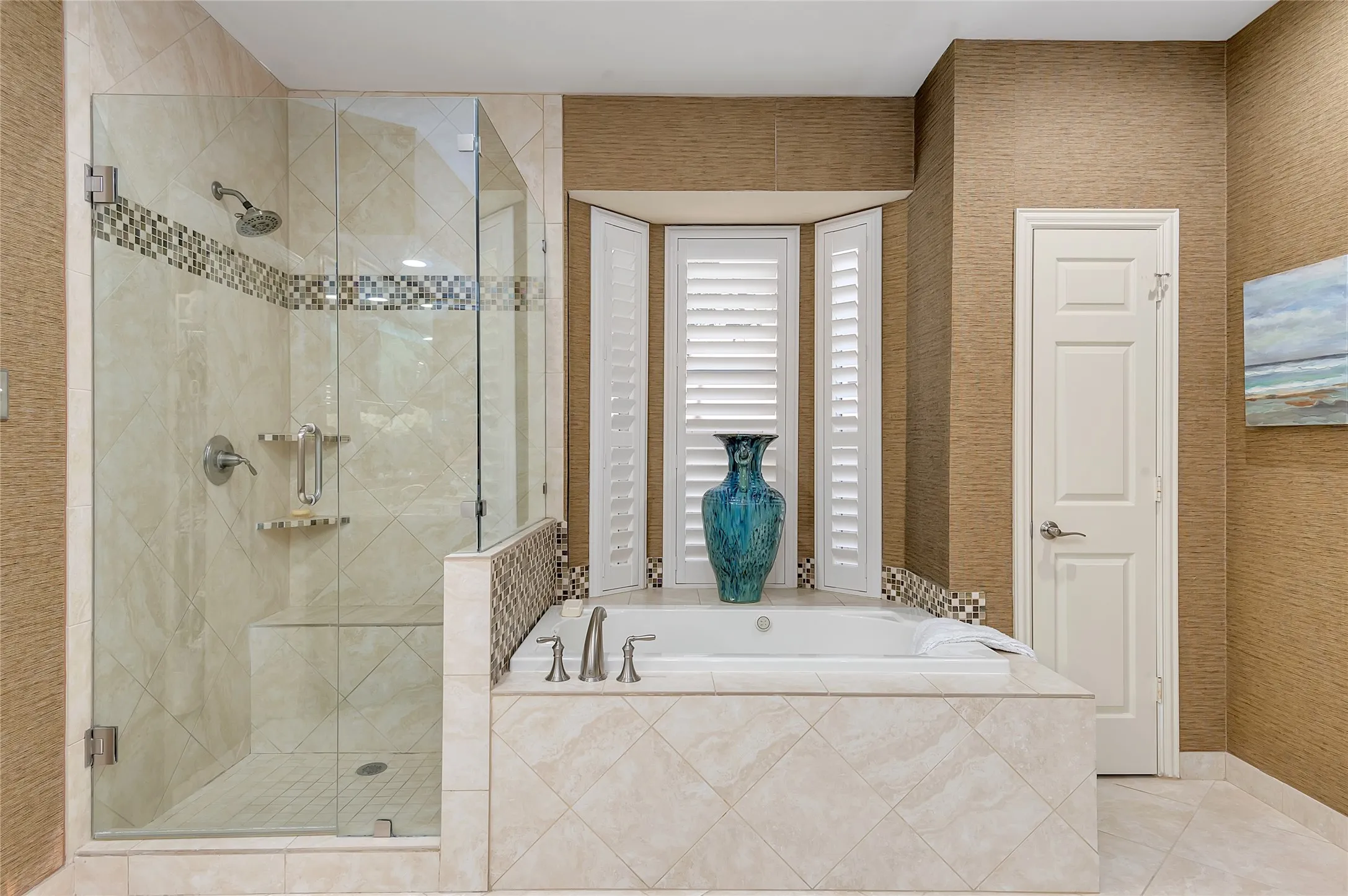 Shower and soaking tub combination featuring a glass enclosure, built-in shower bench, tiled tub surround, and white plantation shutters