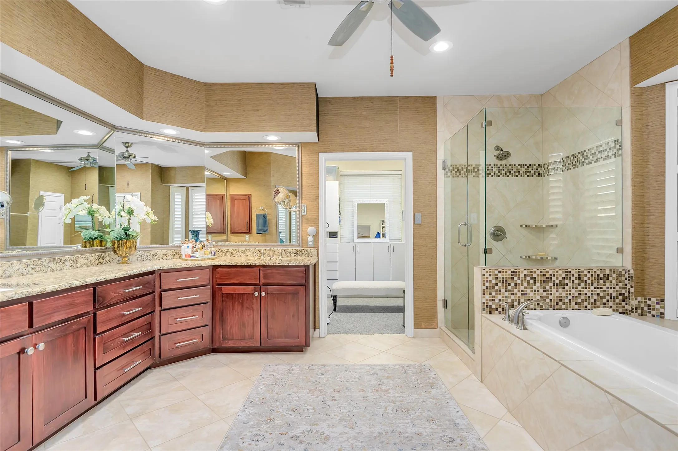 Spacious bathroom featuring a dual vanity with granite countertops and rich wood cabinetry