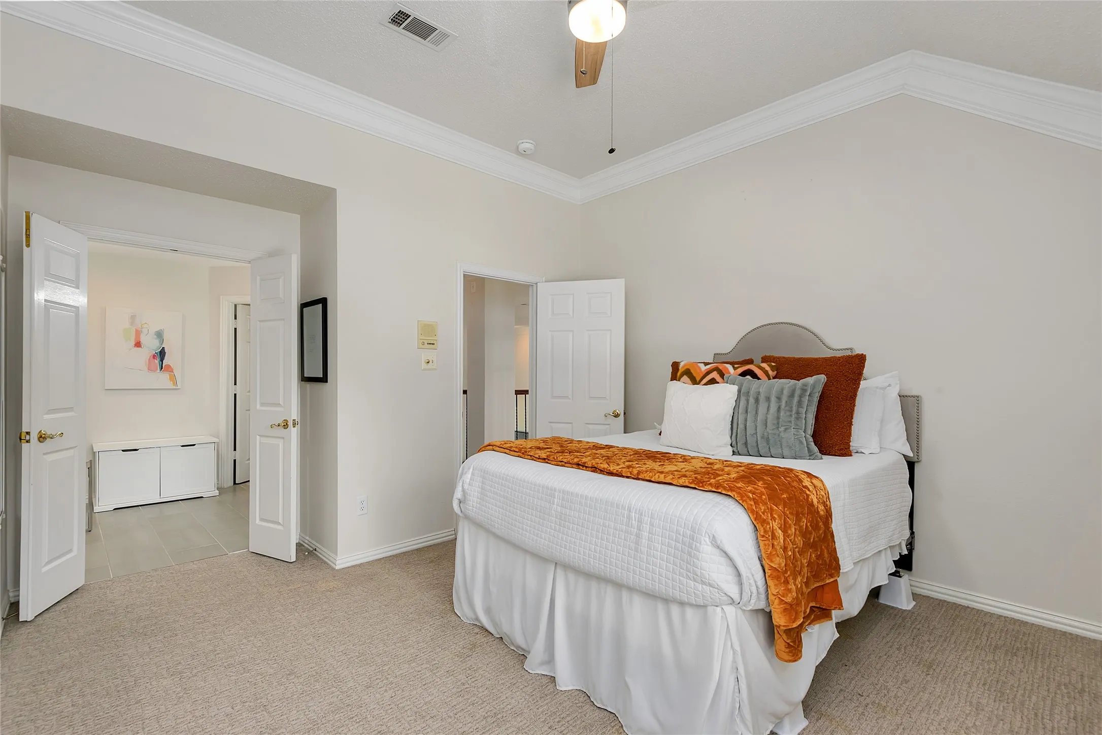 Carpeted room with a vaulted ceiling and white crown molding